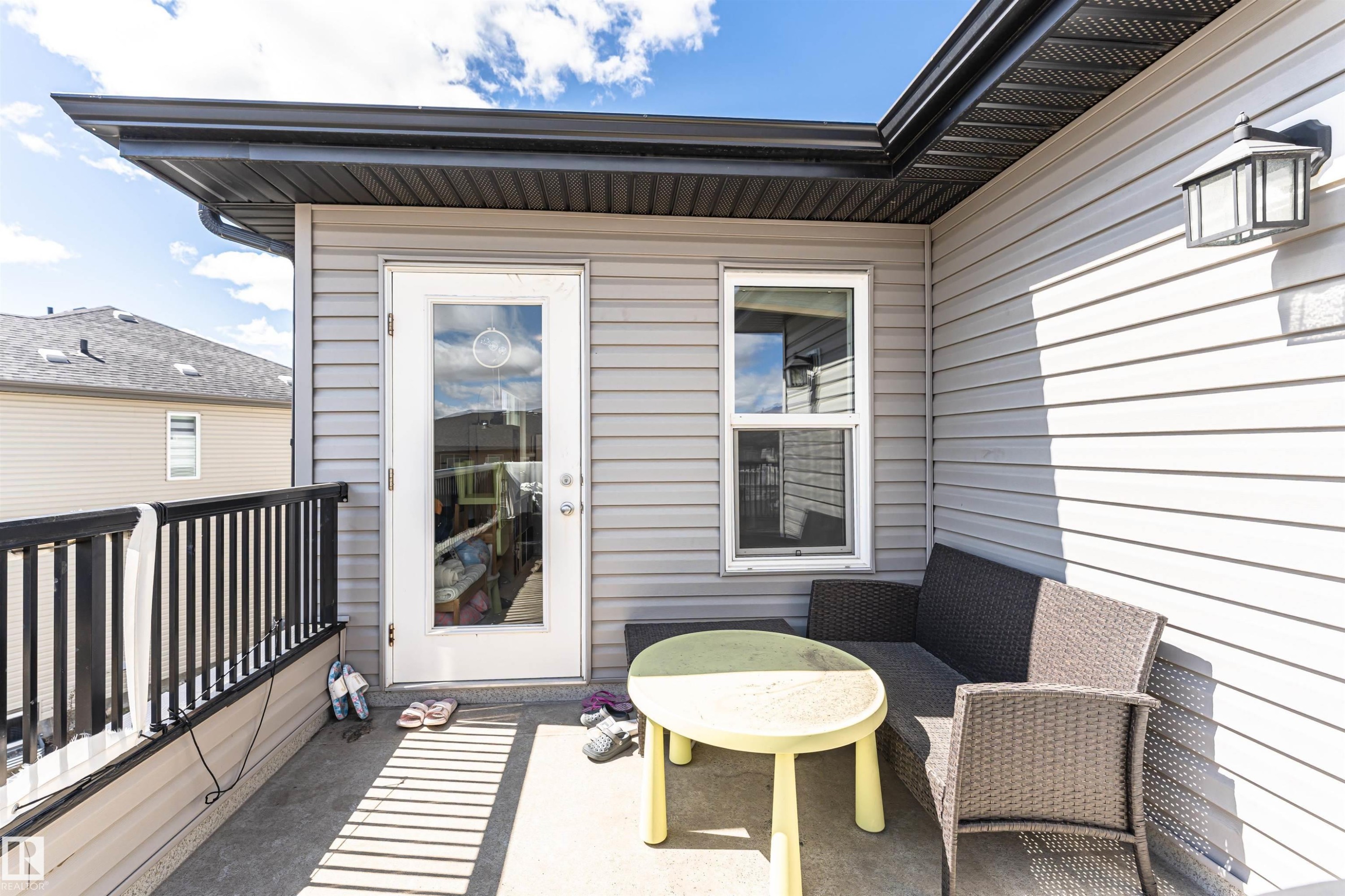 Outdoor balcony featuring gray siding and a black railing - 4452 Annett Common, Edmonton, AB