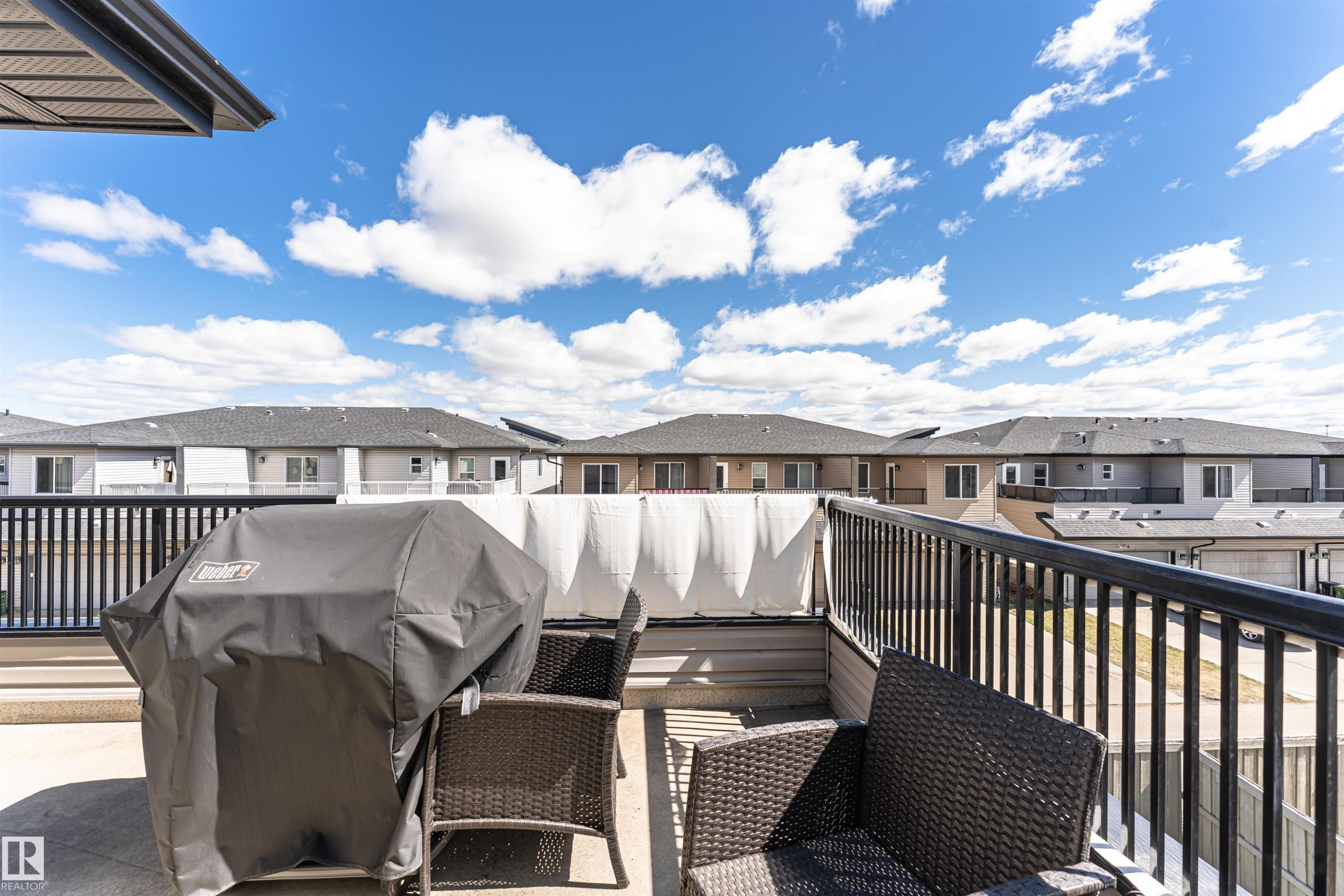 Elevated concrete patio featuring a black metal railing - 4452 Annett Common, Edmonton, AB