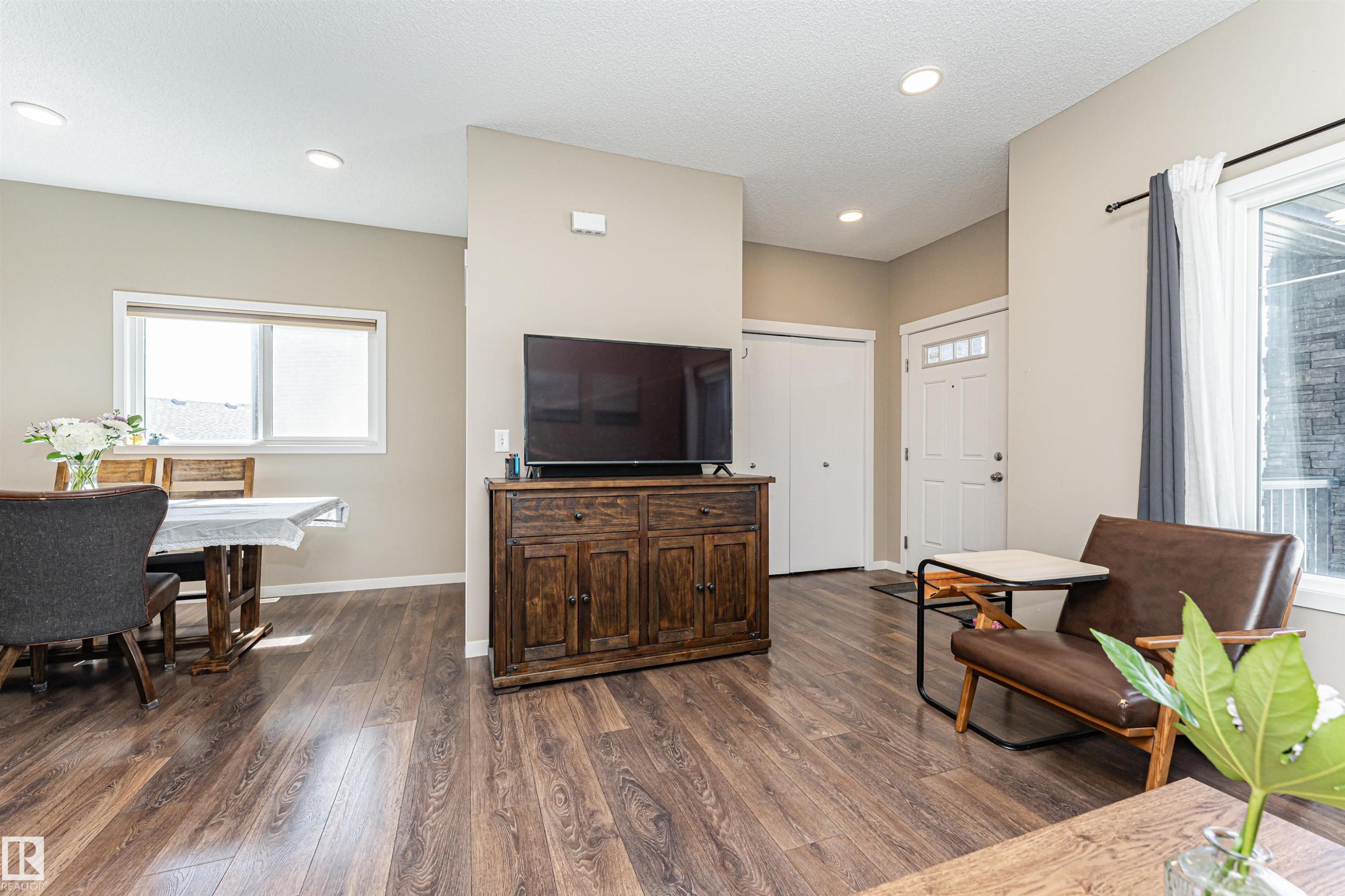 Open-concept living space with wood-finish flooring throughout - 4452 Annett Common, Edmonton, AB