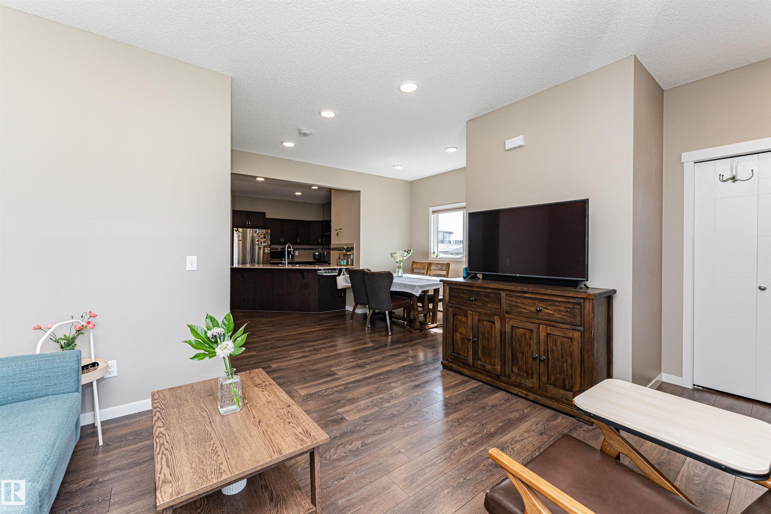 Open concept living area featuring wood-finish flooring, recessed lighting, and neutral wall tones - 4452 Annett Common, Edmonton, AB