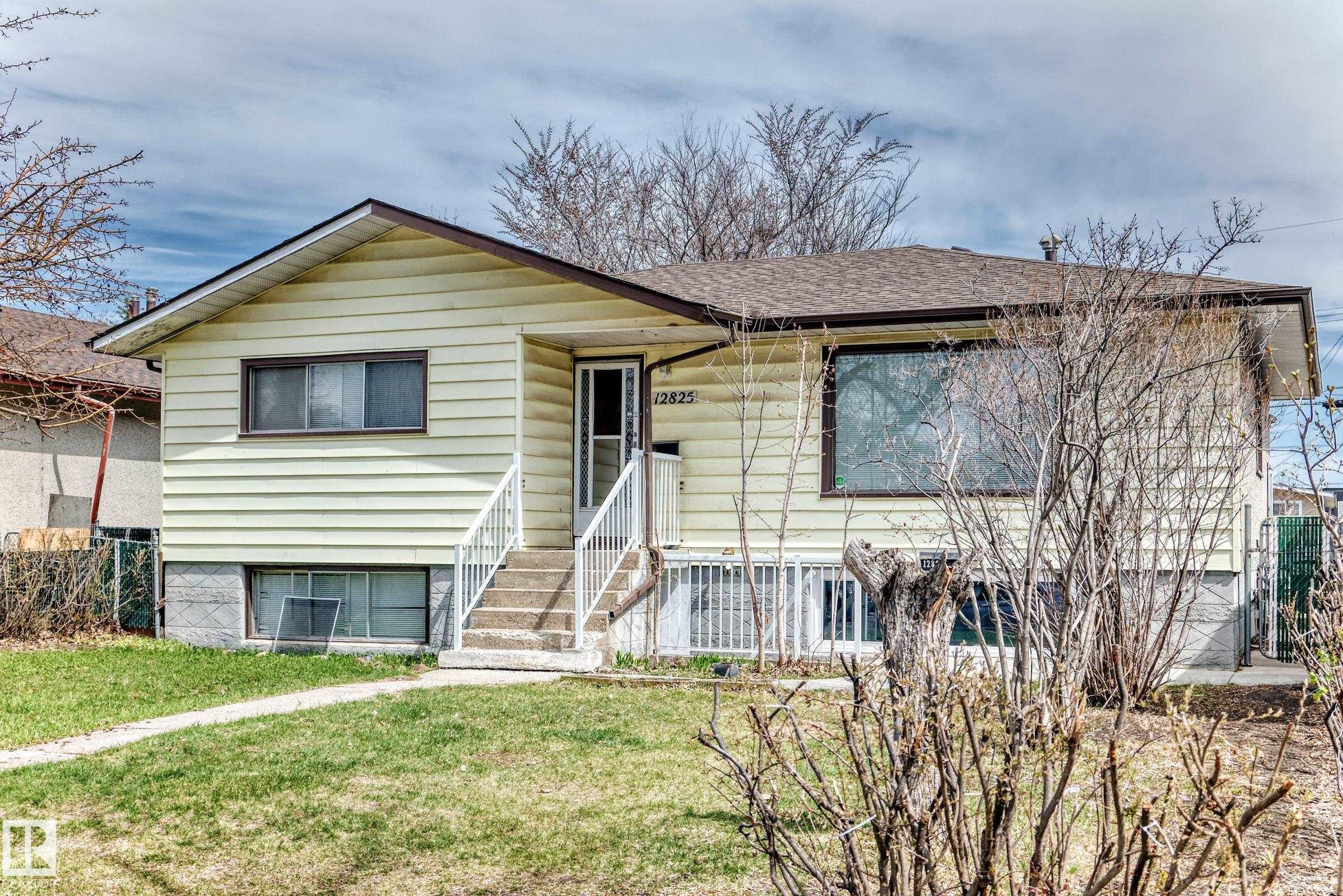 Single-story residence featuring light-colored siding, a brown roof, and a front entry staircase with white railings - 12825 102 Street, Edmonton, AB - Outdoor