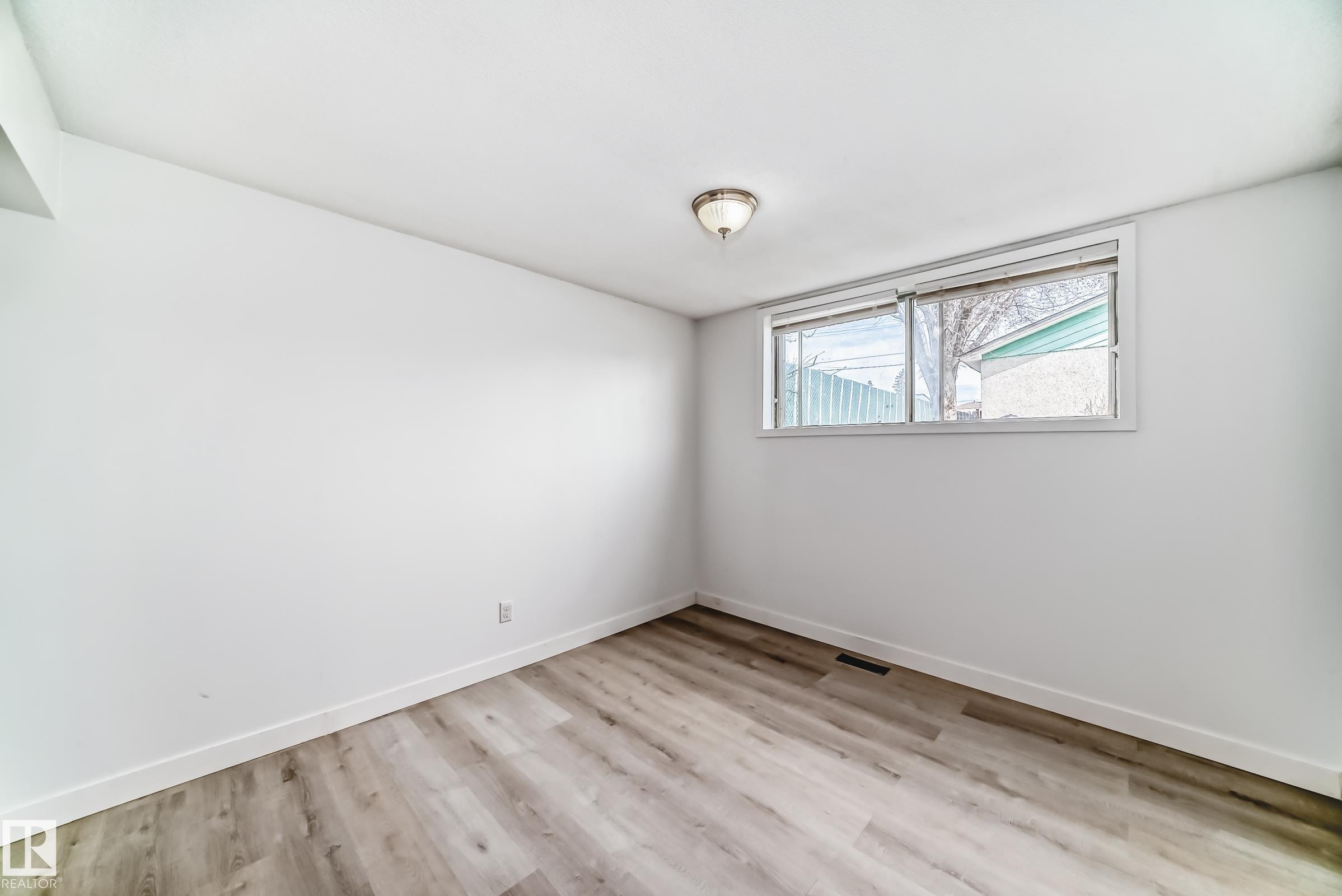 Room featuring light wood-finish flooring, white walls, and a single window - 12825 102 Street, Edmonton, AB - Indoor Photo Showing Other Room