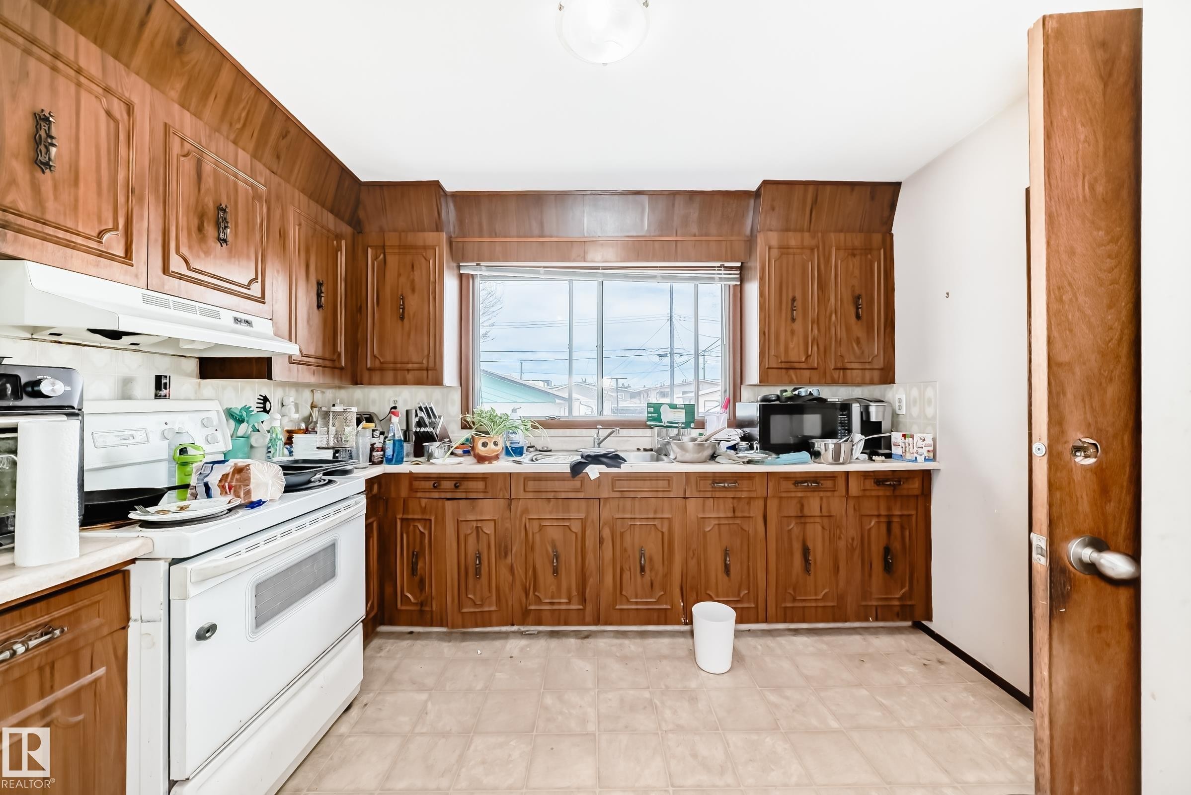 Kitchen featuring wood-finish cabinetry, white countertops, and white appliances - 12825 102 Street, Edmonton, AB - Indoor Photo Showing Kitchen