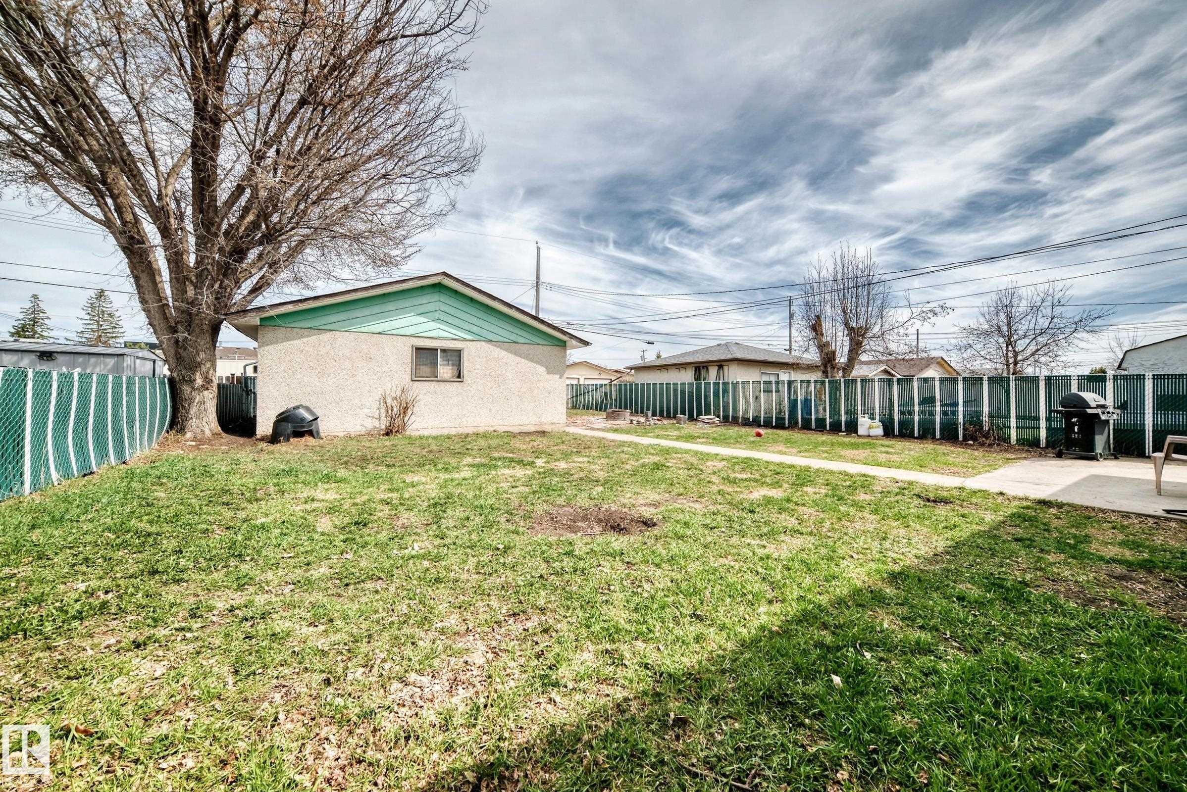 Detached structure featuring stucco siding and a teal gable accent - 12825 102 Street, Edmonton, AB - Outdoor