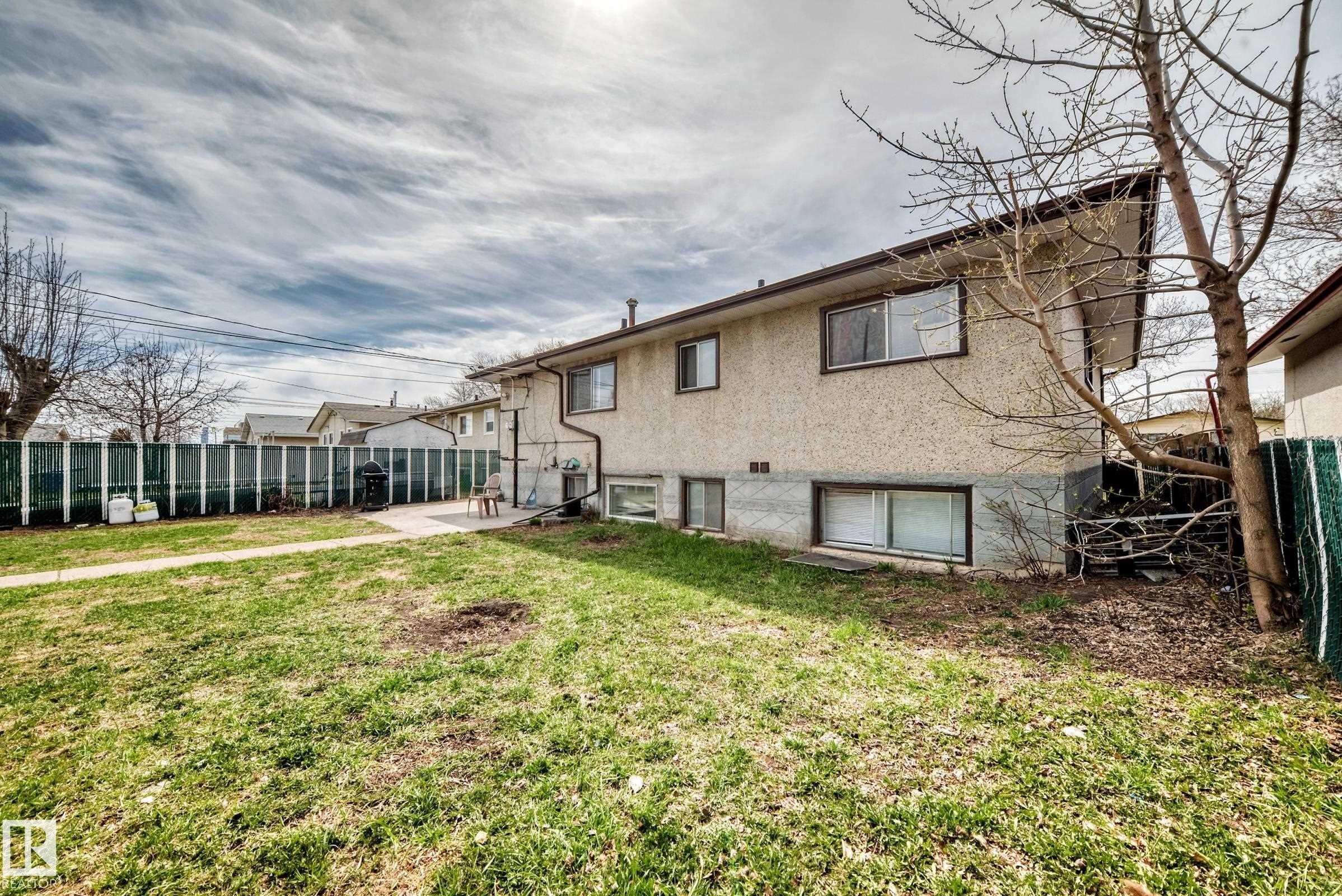 Expansive grassy yard with a concrete patio - 12825 102 Street, Edmonton, AB - Outdoor