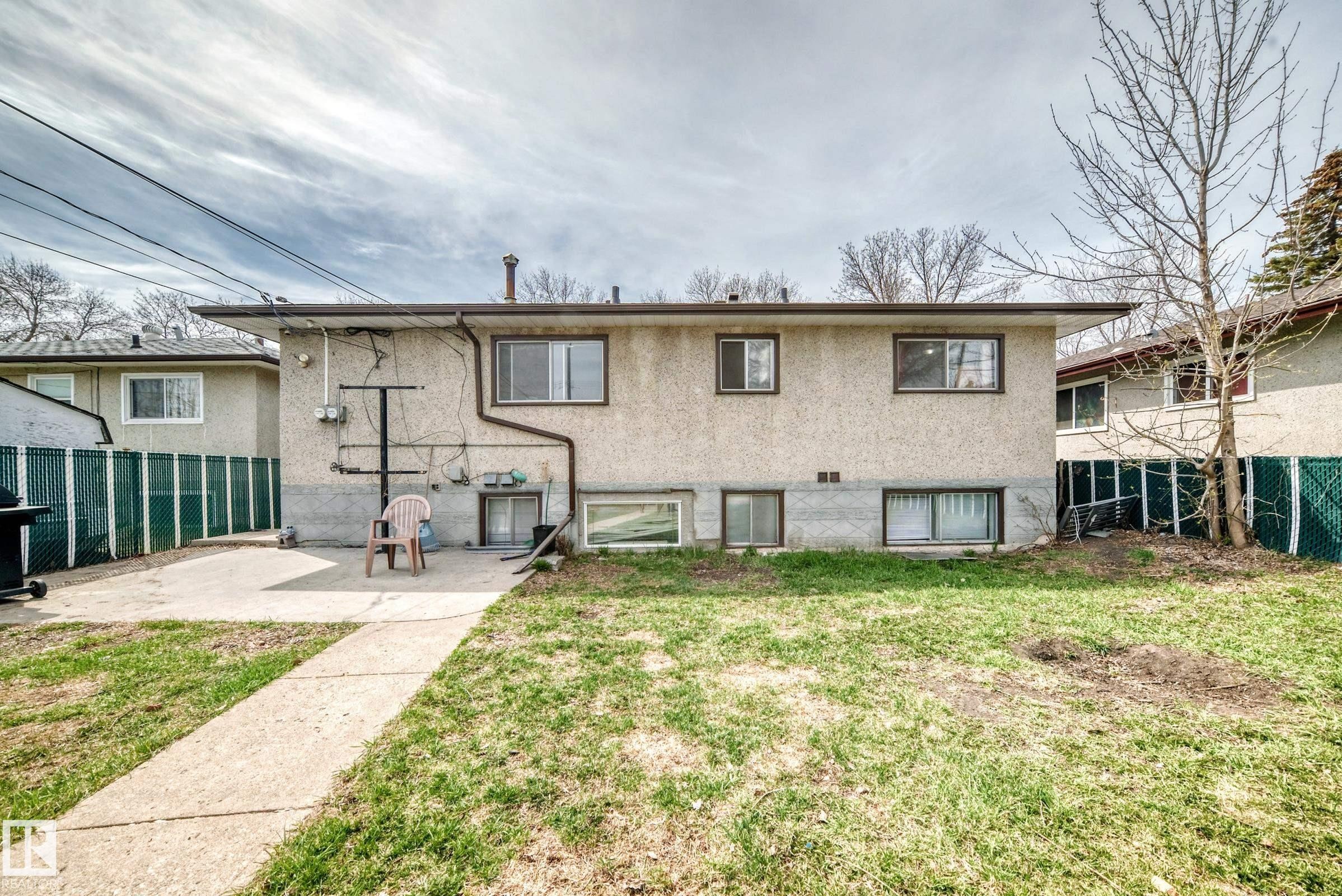 Rear exterior with stucco siding and multiple windows - 12825 102 Street, Edmonton, AB - Outdoor