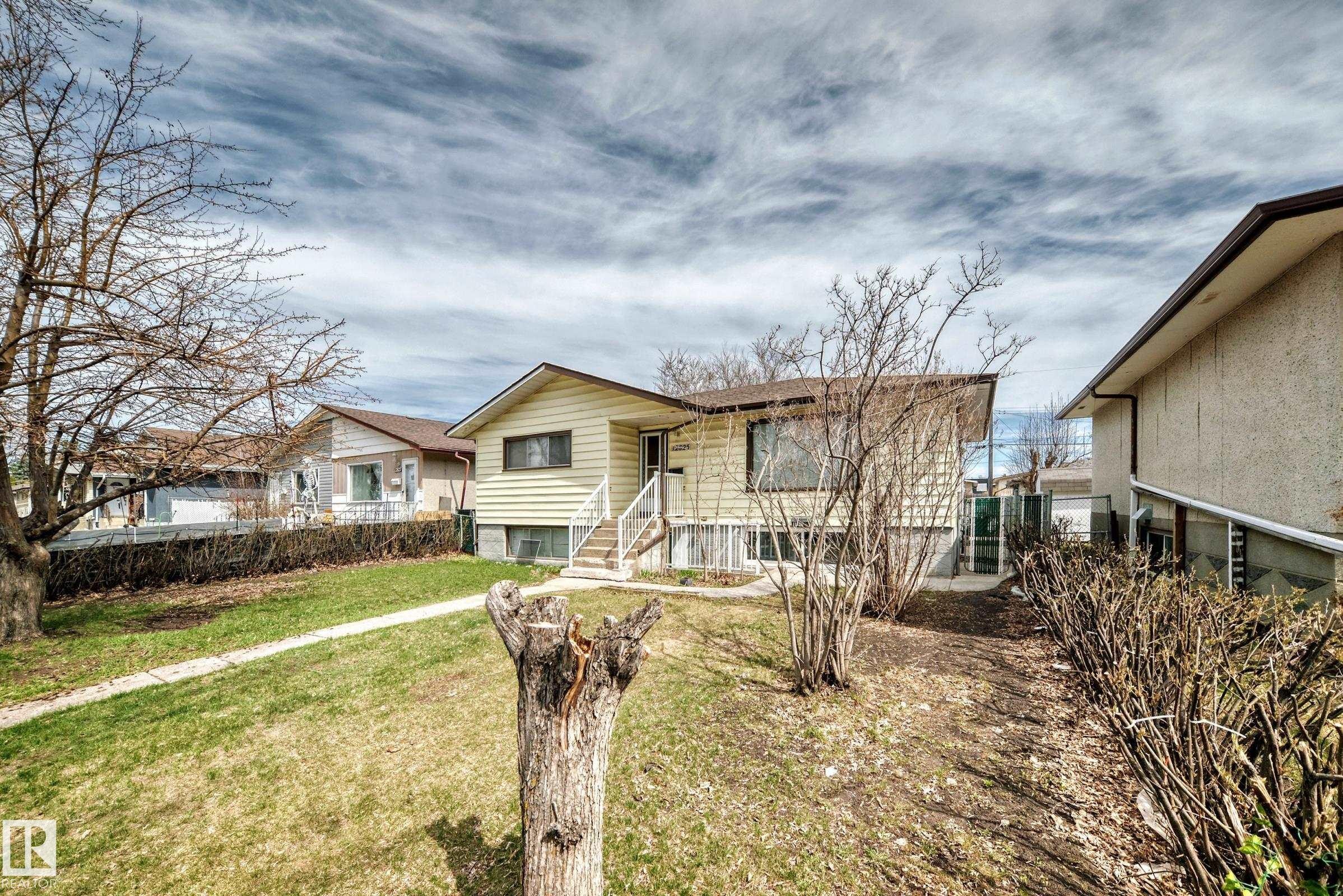 Split-level residence featuring light-colored siding and a brown shingle roof - 12825 102 Street, Edmonton, AB - Outdoor