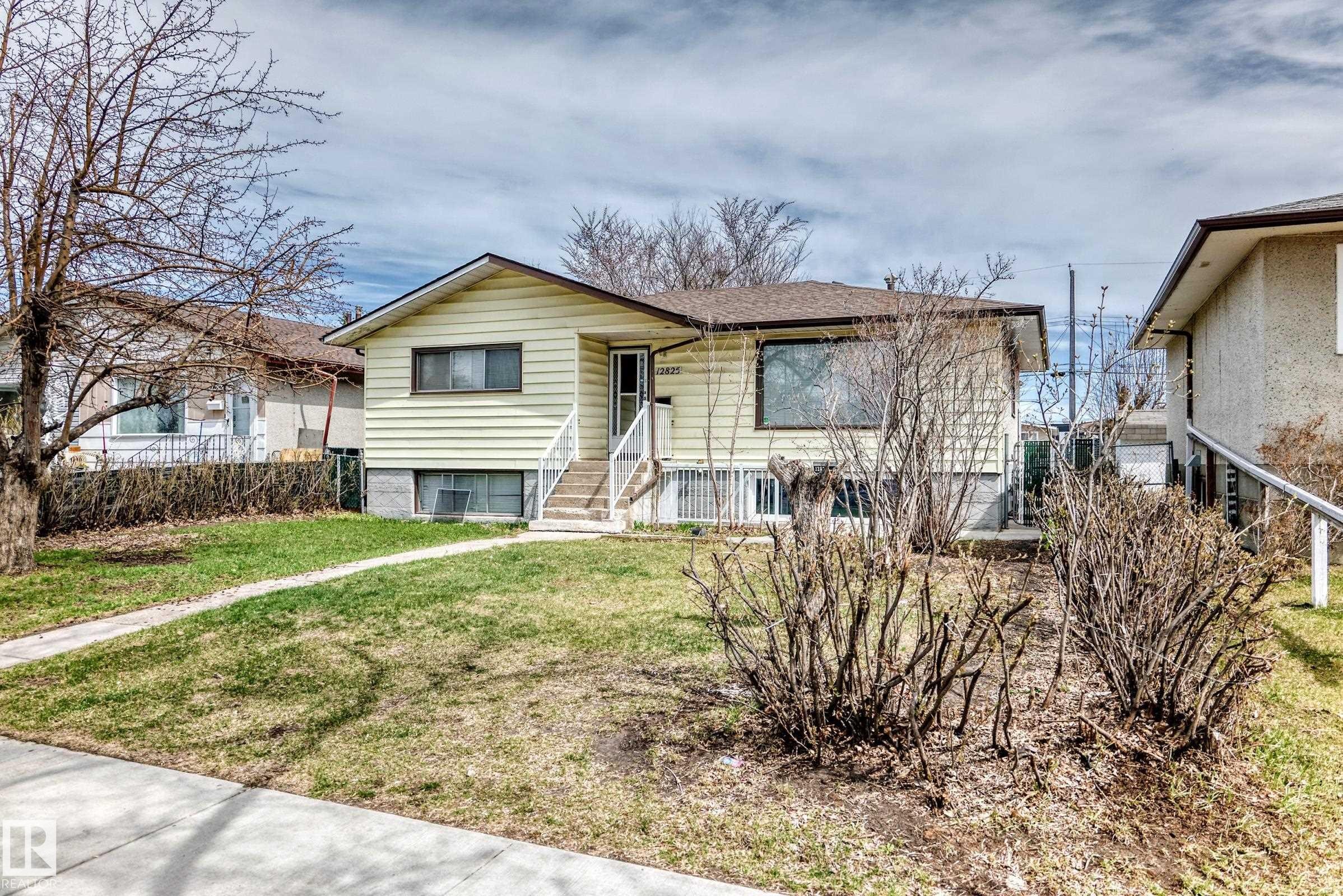 Light yellow siding exterior with a dark brown shingled roof - 12825 102 Street, Edmonton, AB - Outdoor