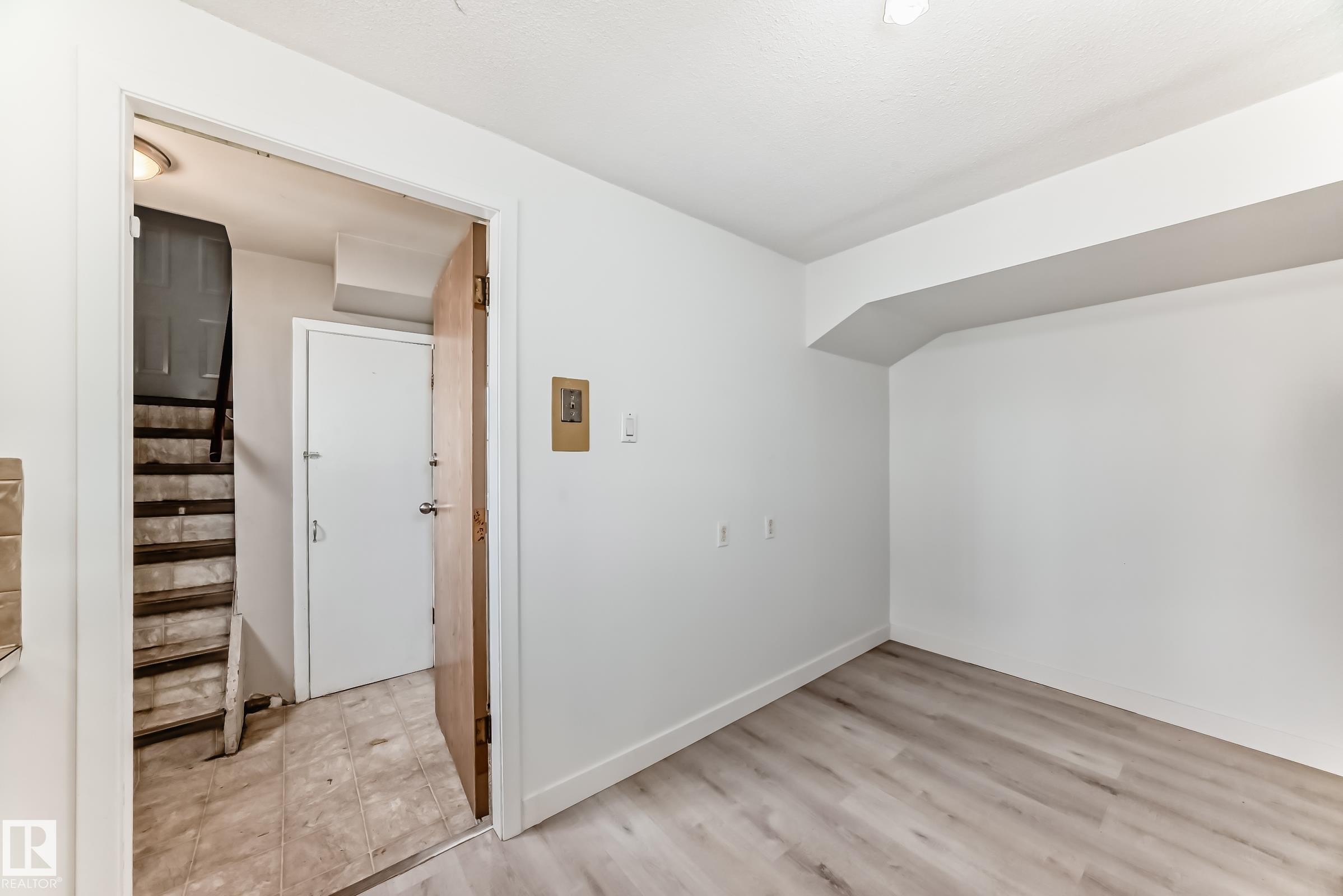 Bright interior space featuring light wood-finish flooring and white painted walls - 12825 102 Street, Edmonton, AB - Indoor Photo Showing Other Room