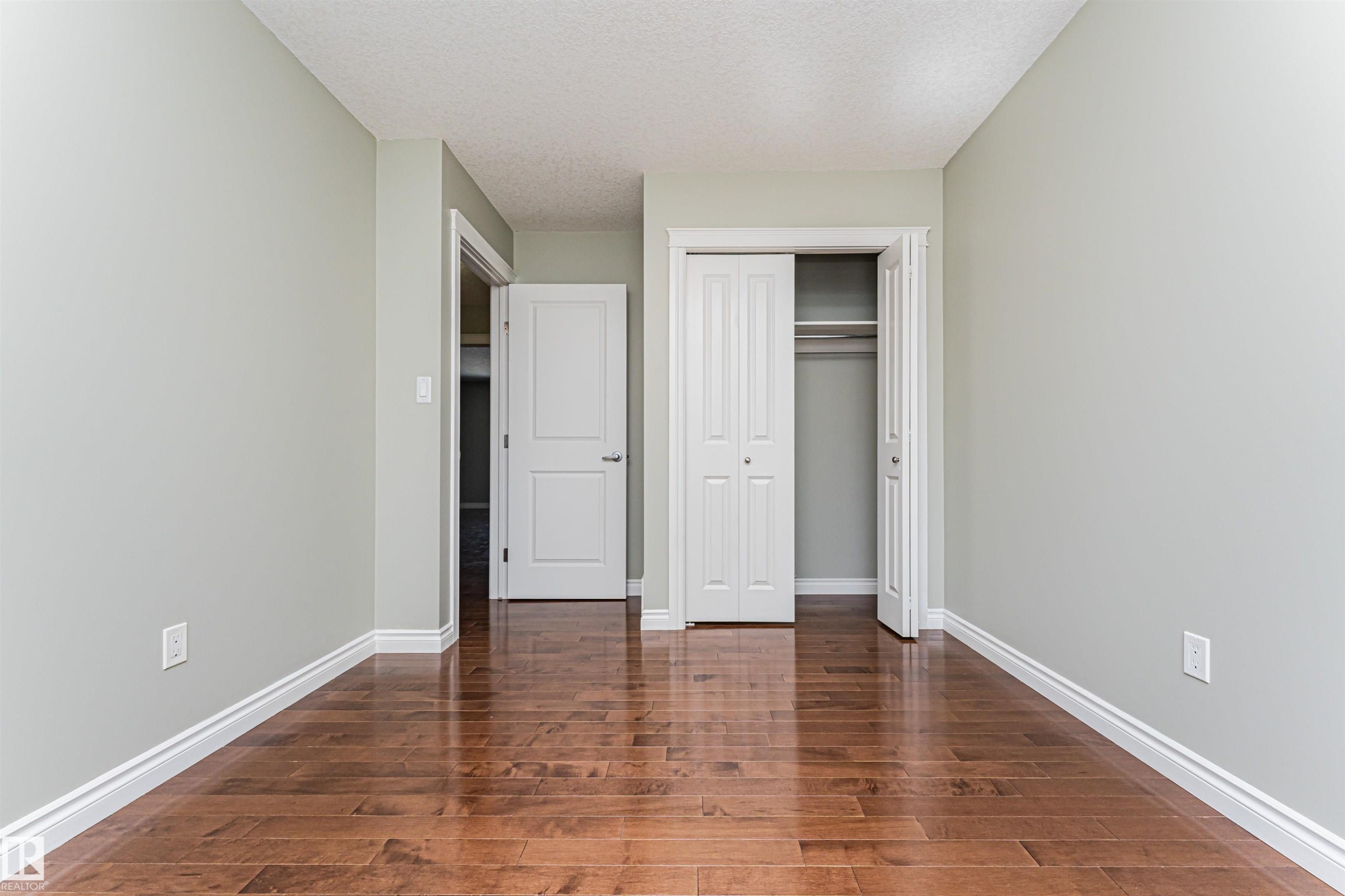 Room featuring wood-finish flooring, light-toned wall paint, and white trim molding - 8530 76 Avenue, Edmonton, AB - Indoor Photo Showing Other Room