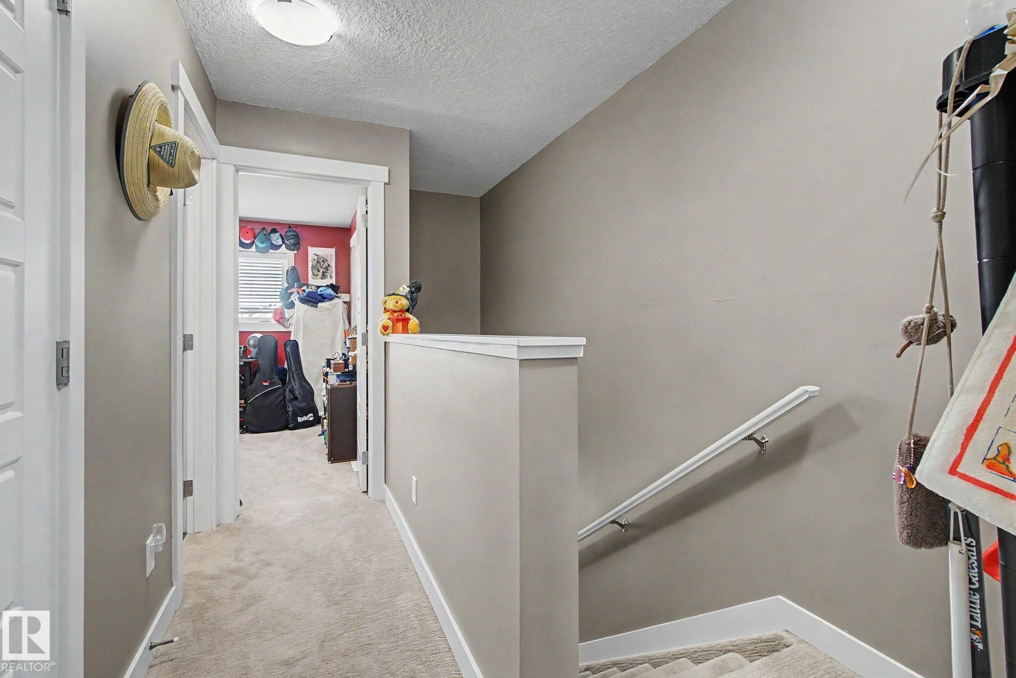 Carpeted hallway with painted walls, white trim, and a flush-mount ceiling light - 210 401 Southfork Drive, Leduc, AB - Indoor Photo Showing Other Room