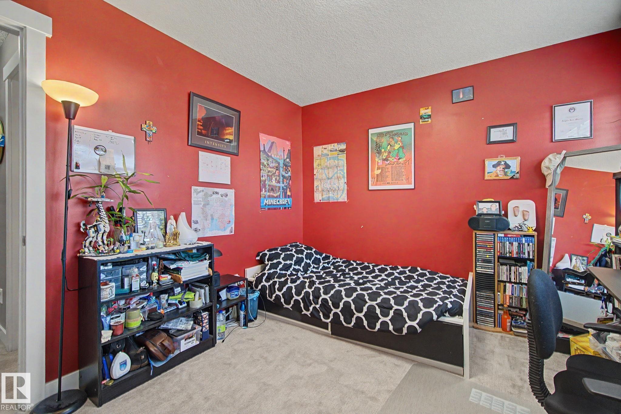 Carpeted room featuring vibrant red walls and white trim - 210 401 Southfork Drive, Leduc, AB - Indoor Photo Showing Bedroom