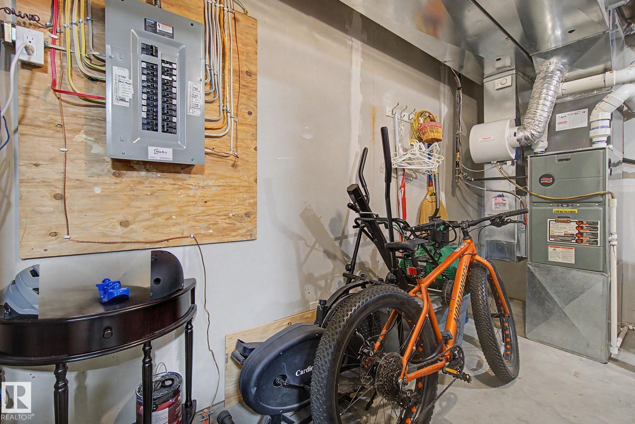 Utility area featuring a circuit breaker panel mounted on wood, a forced-air furnace, and a humidifier attachment - 210 401 Southfork Drive, Leduc, AB - Indoor Photo Showing Basement