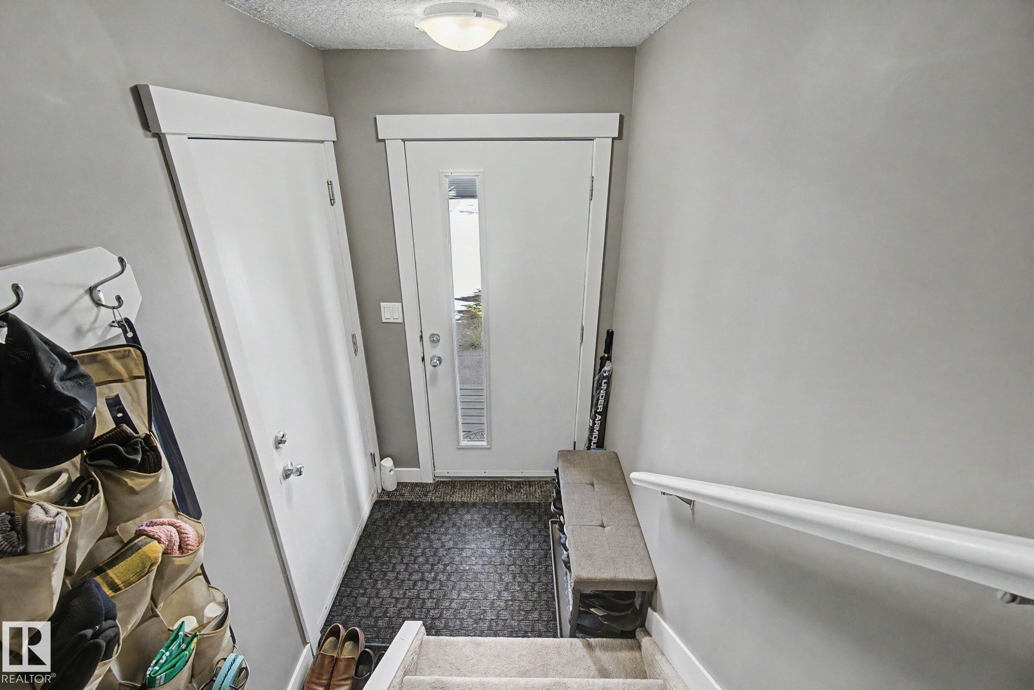 Entryway featuring a solid core door, sidelight window, flush mount ceiling light, and light gray wall paint - 210 401 Southfork Drive, Leduc, AB - Indoor Photo Showing Other Room