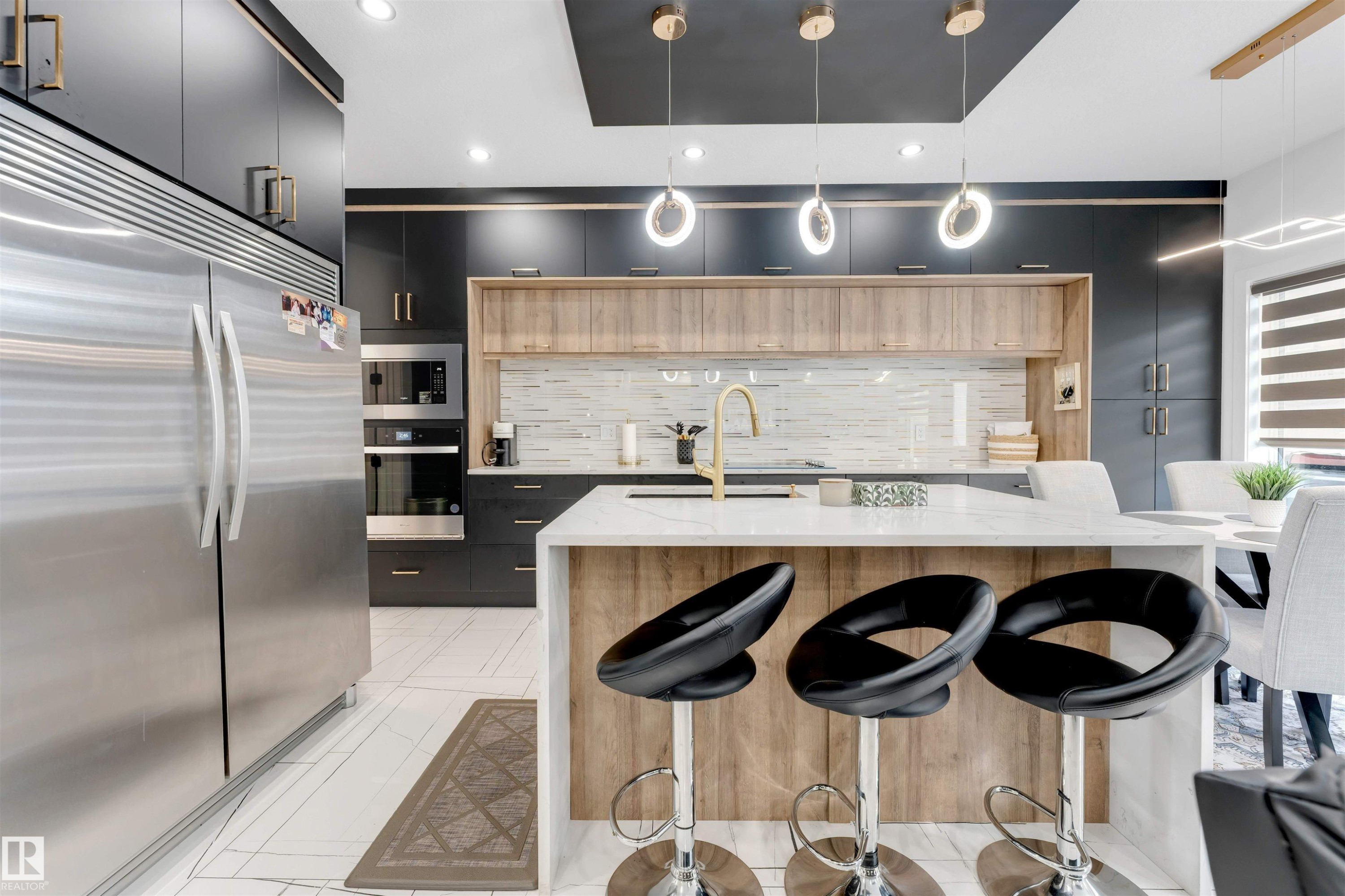 Gourmet kitchen with a large central island, white countertop, and gold-finish fixtures - 1827 17 Avenue, Edmonton, AB - Indoor Photo Showing Kitchen With Upgraded Kitchen