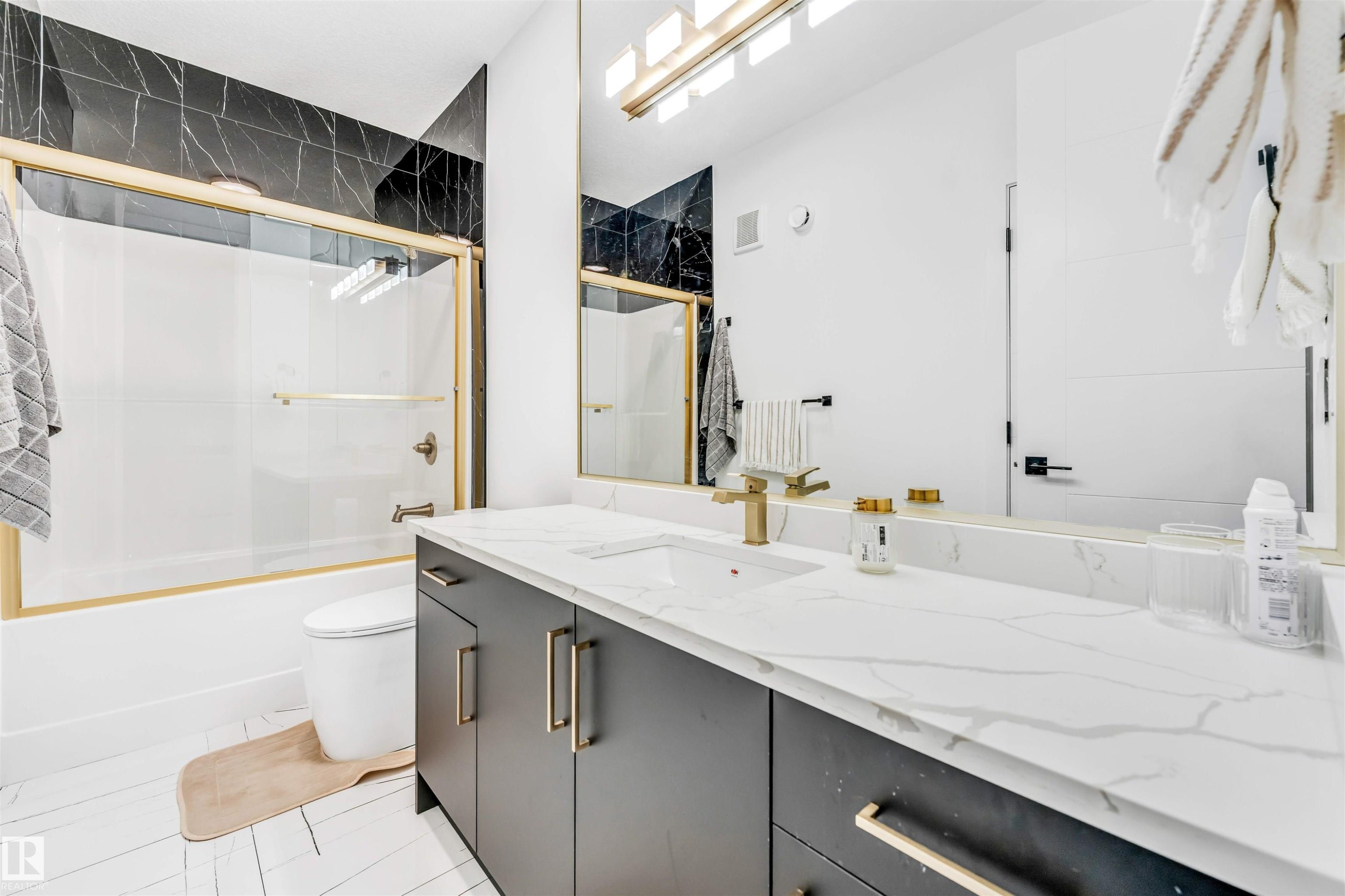 Modern bathroom featuring a single vanity with a white countertop and gold-toned fixtures - 1827 17 Avenue, Edmonton, AB - Indoor Photo Showing Bathroom