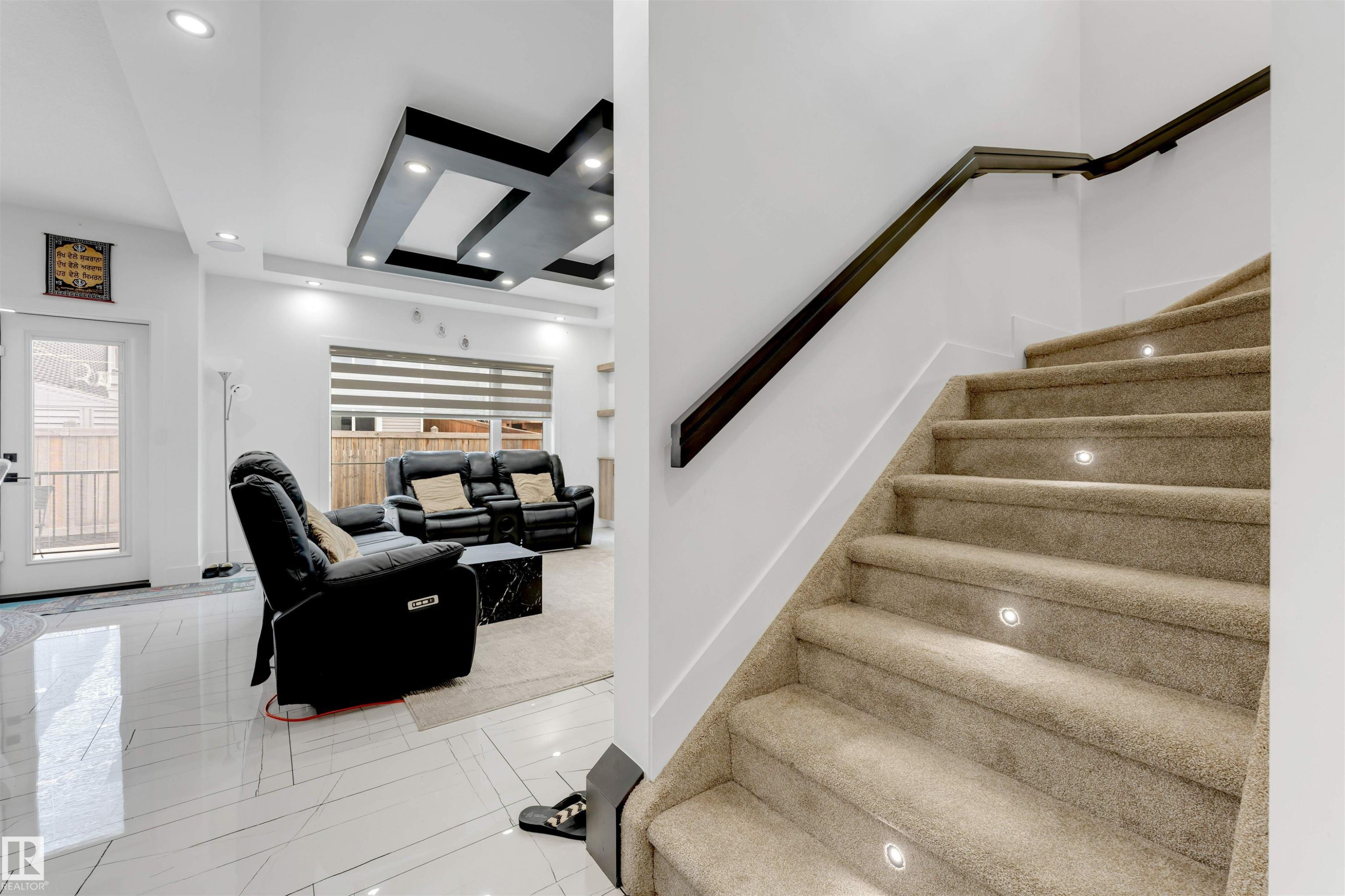 Carpeted staircase with integrated step lighting and a dark wood-finish handrail - 1827 17 Avenue, Edmonton, AB - Indoor Photo Showing Other Room