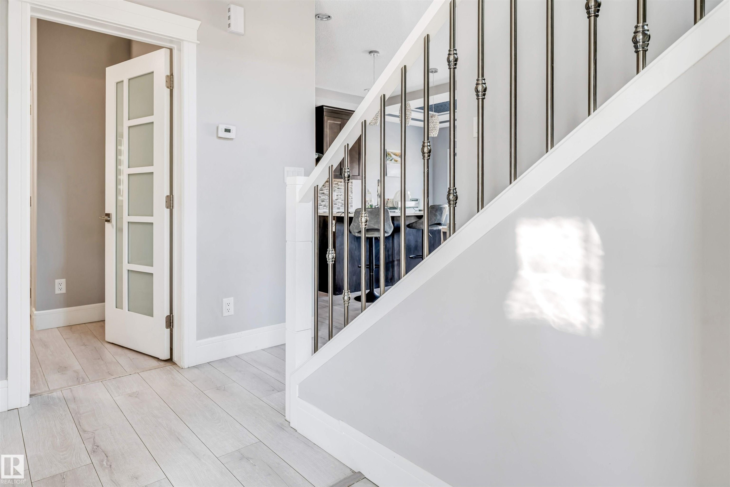 Staircase featuring decorative metal balusters and white handrails - 1103 29 Street, Edmonton, AB - Indoor Photo Showing Other Room