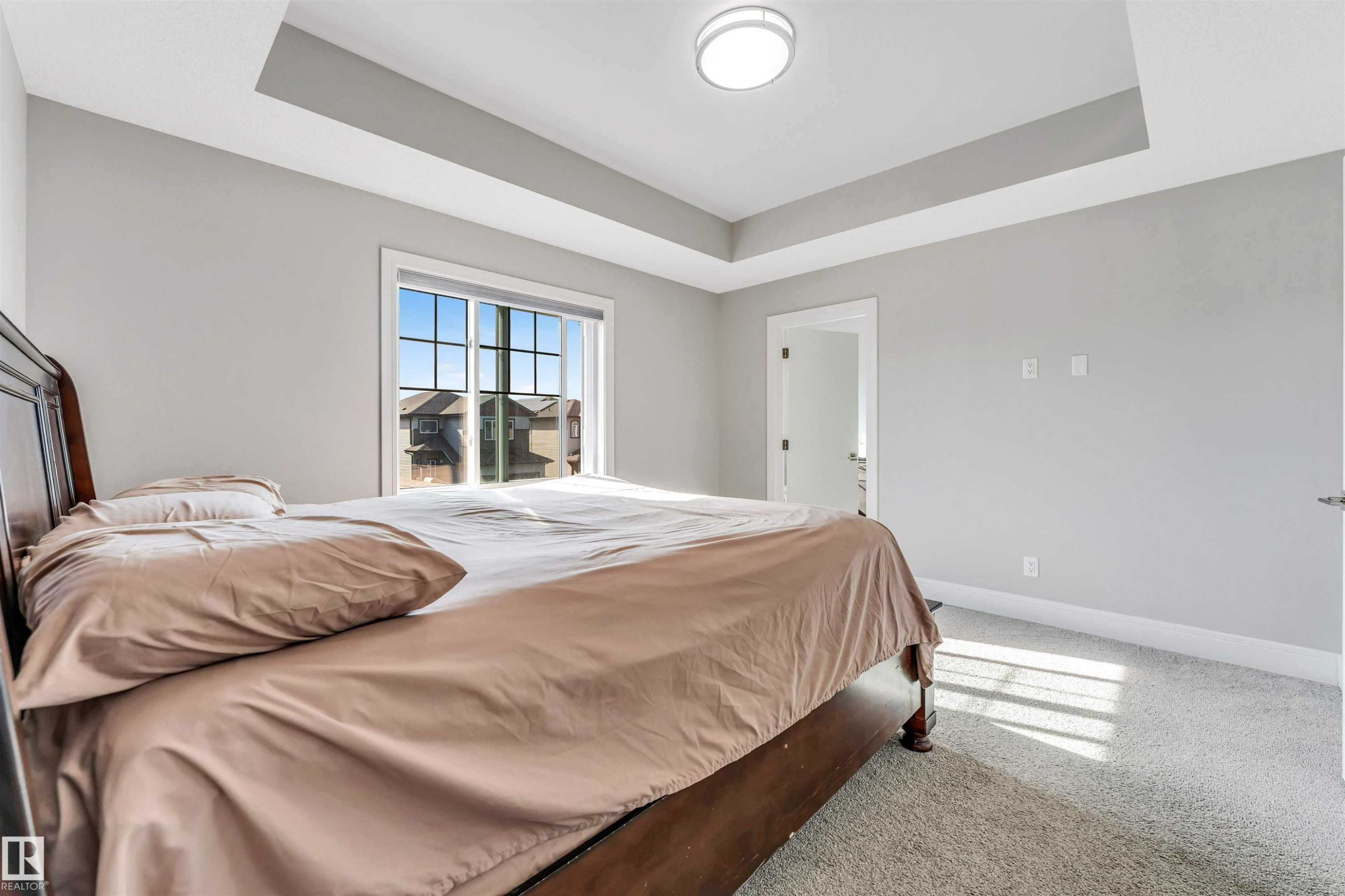 Bedroom featuring a tray ceiling, recessed window, and light gray wall paint - 1103 29 Street, Edmonton, AB - Indoor Photo Showing Bedroom