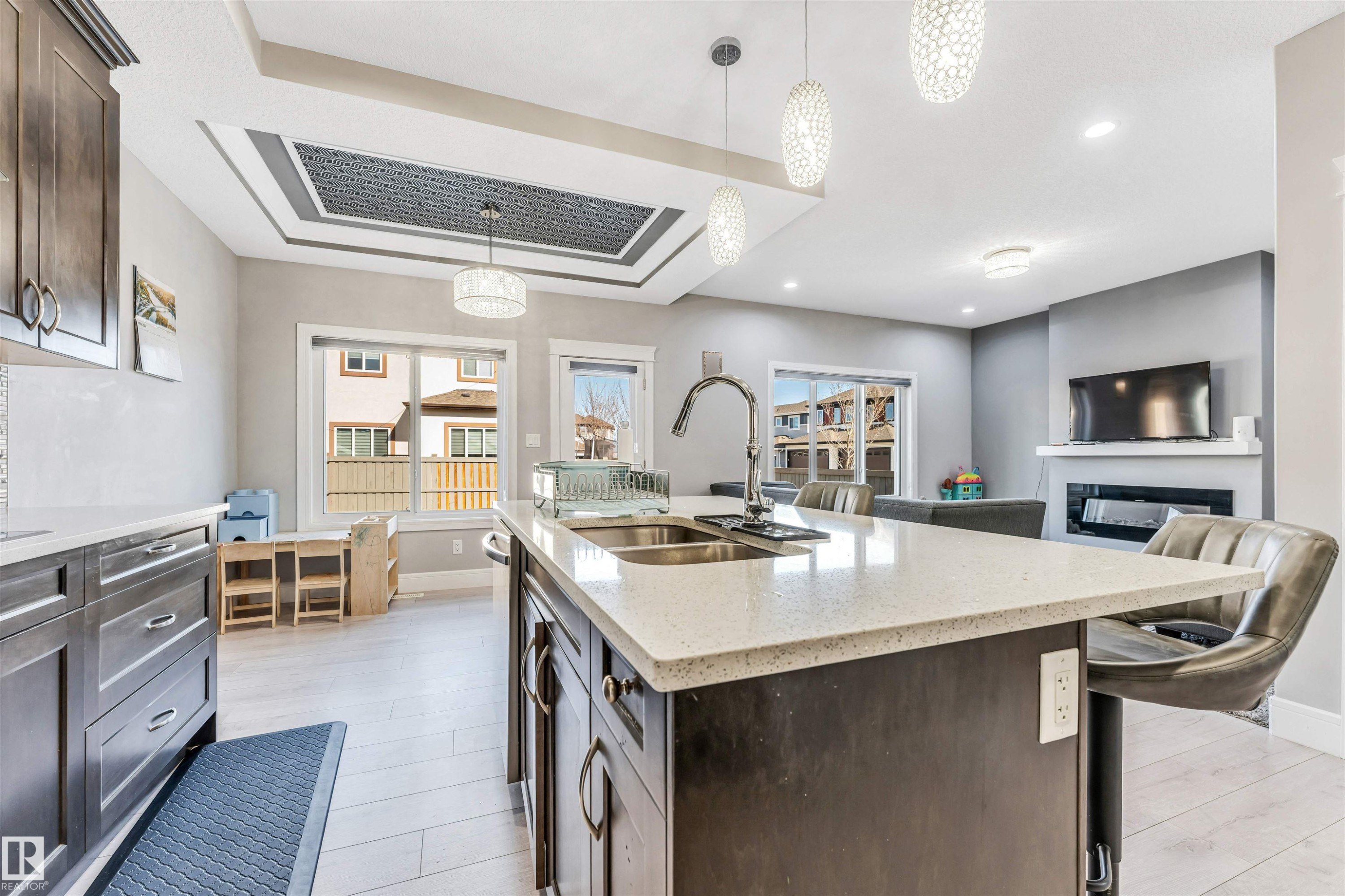 Open-concept kitchen with a large island featuring a double sink and ample counter space, dark wood-finish cabinetry, and recessed lighting - 1103 29 Street, Edmonton, AB - Indoor Photo Showing Kitchen With Double Sink With Upgraded Kitchen
