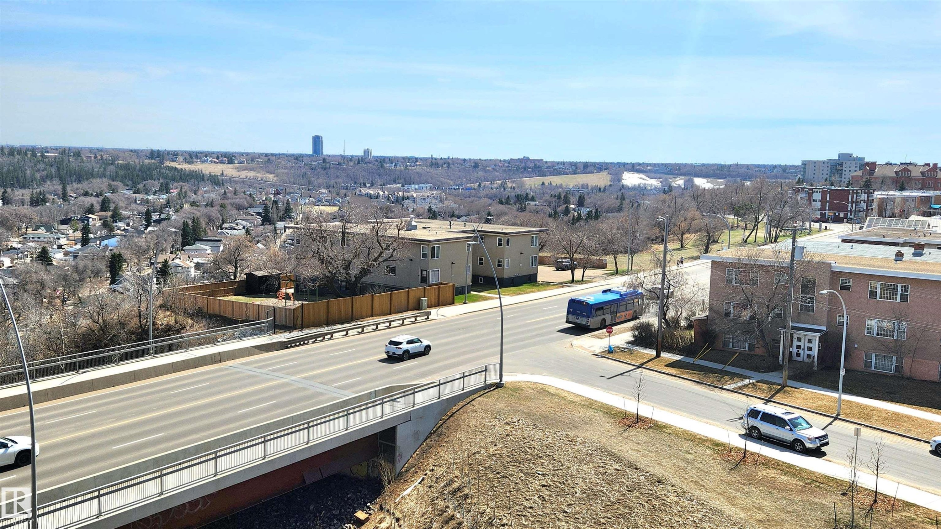 Expansive urban landscape featuring a multi-lane roadway, established neighborhood structures, and distant natural terrain - 603 9028 Jasper Avenue, Edmonton, AB - Outdoor With View