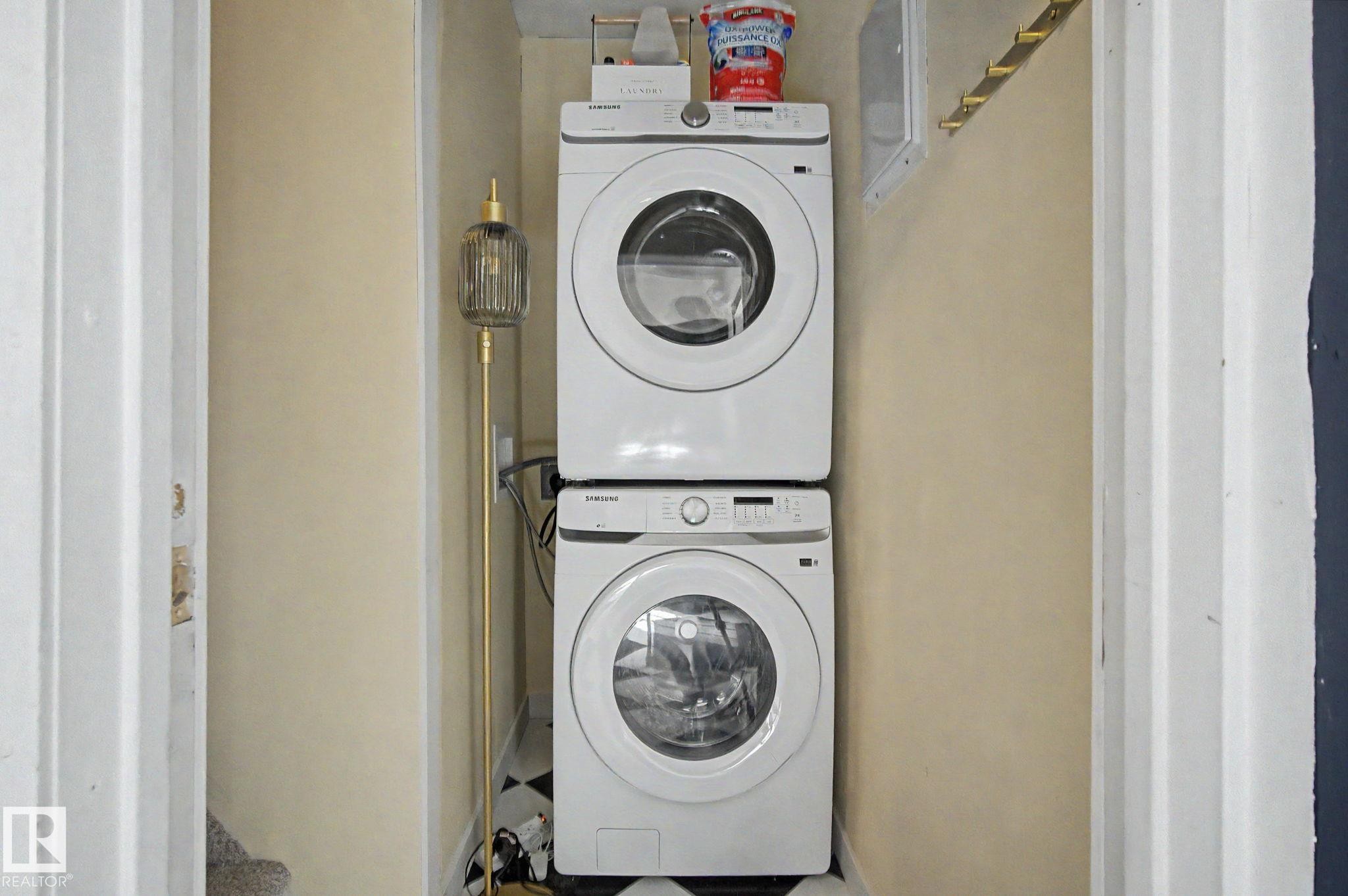 Dedicated laundry area featuring stacked front-loading appliances - 11512 122 St, Edmonton, AB - Indoor Photo Showing Laundry Room