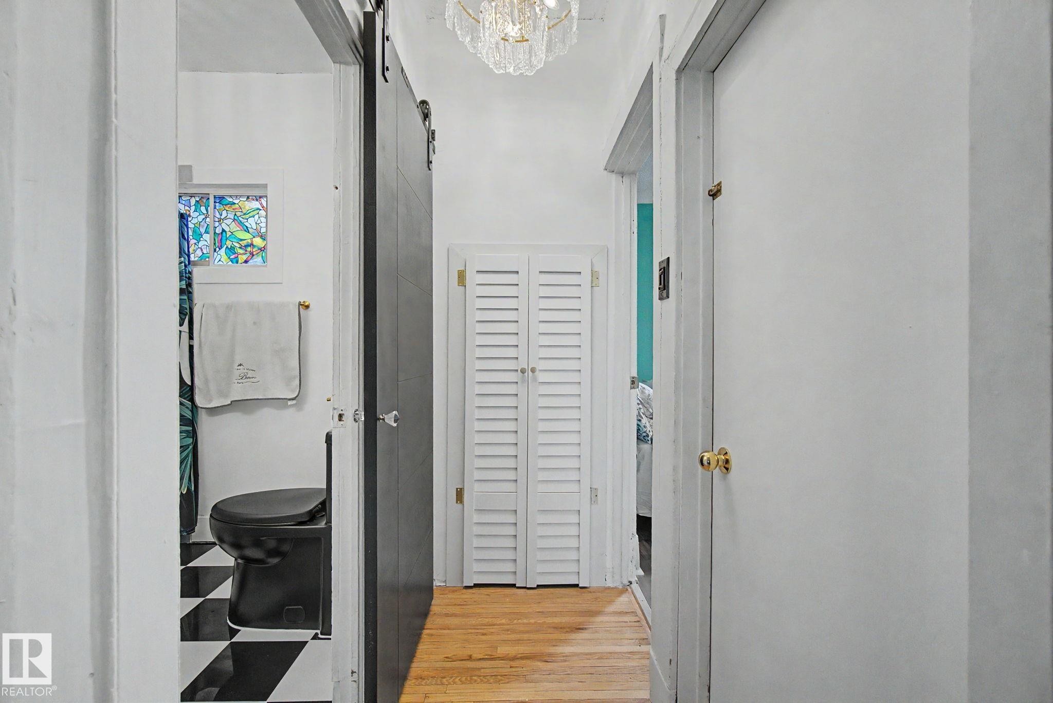 Hallway featuring wood-finish flooring and a crystal chandelier - 11512 122 St, Edmonton, AB - Indoor Photo Showing Other Room