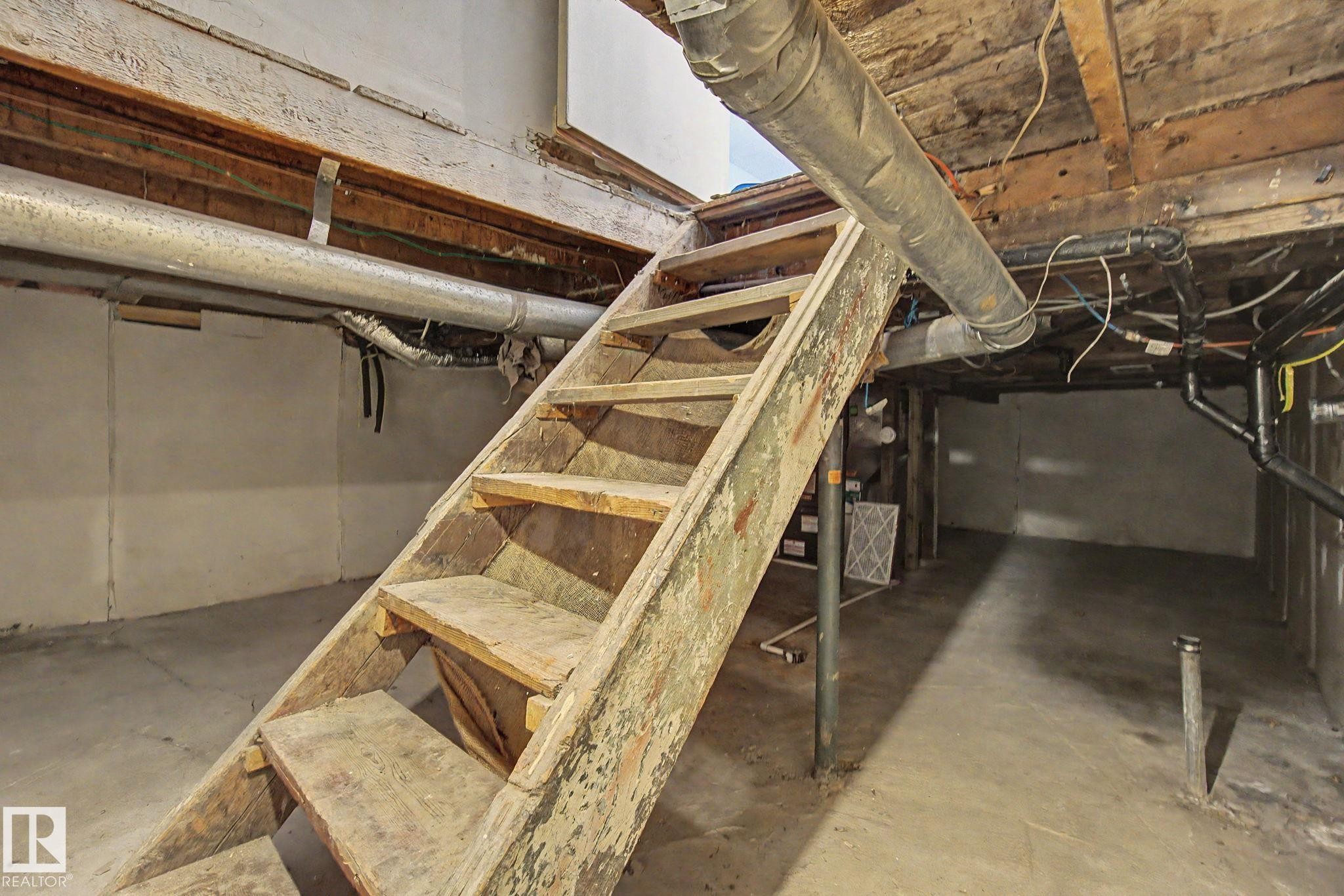 Unfinished basement featuring exposed wood ceiling joists and concrete flooring - 11512 122 St, Edmonton, AB - Indoor