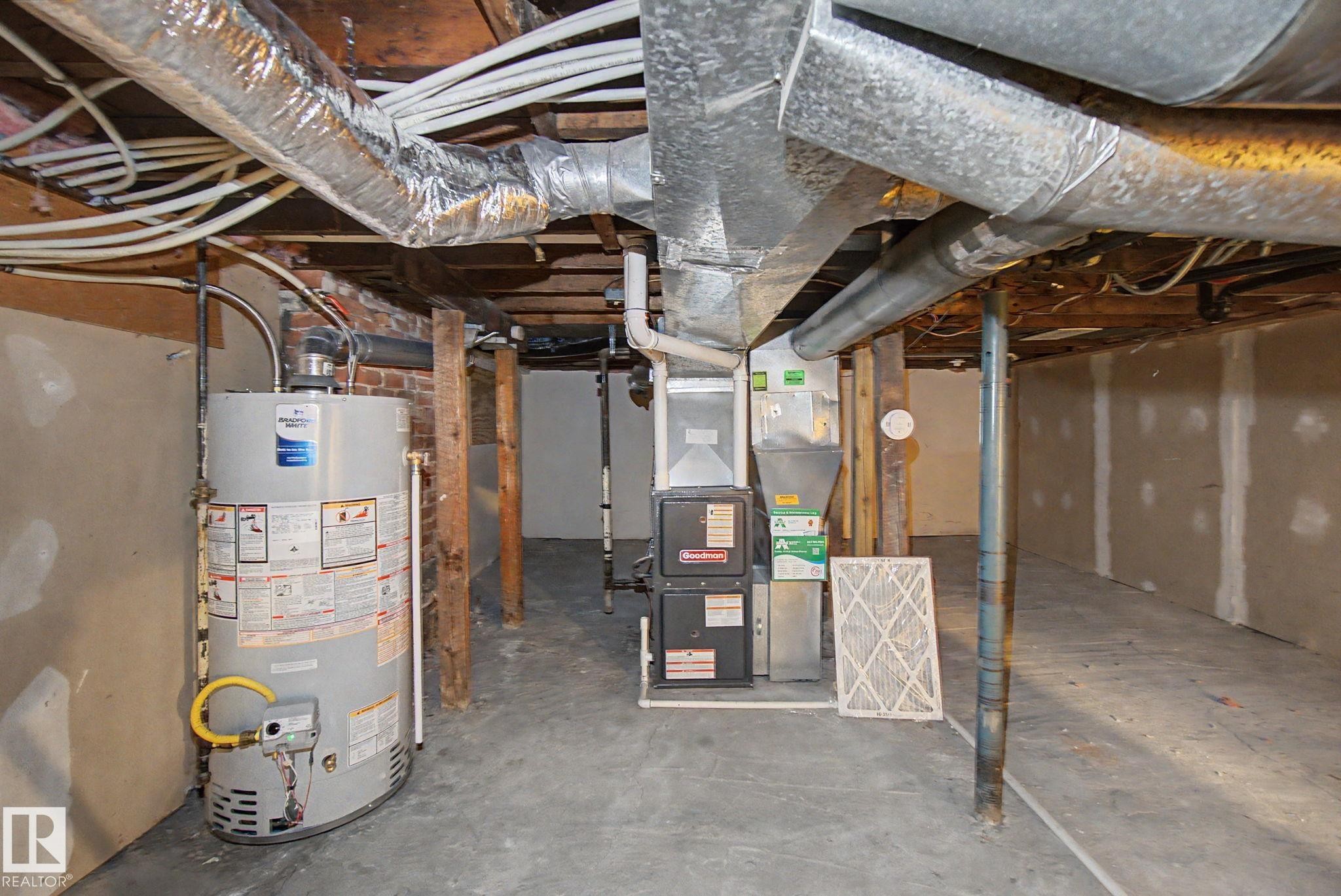 Basement utility area featuring a water heater, furnace, exposed ductwork, and PEX plumbing - 11512 122 St, Edmonton, AB - Indoor Photo Showing Basement