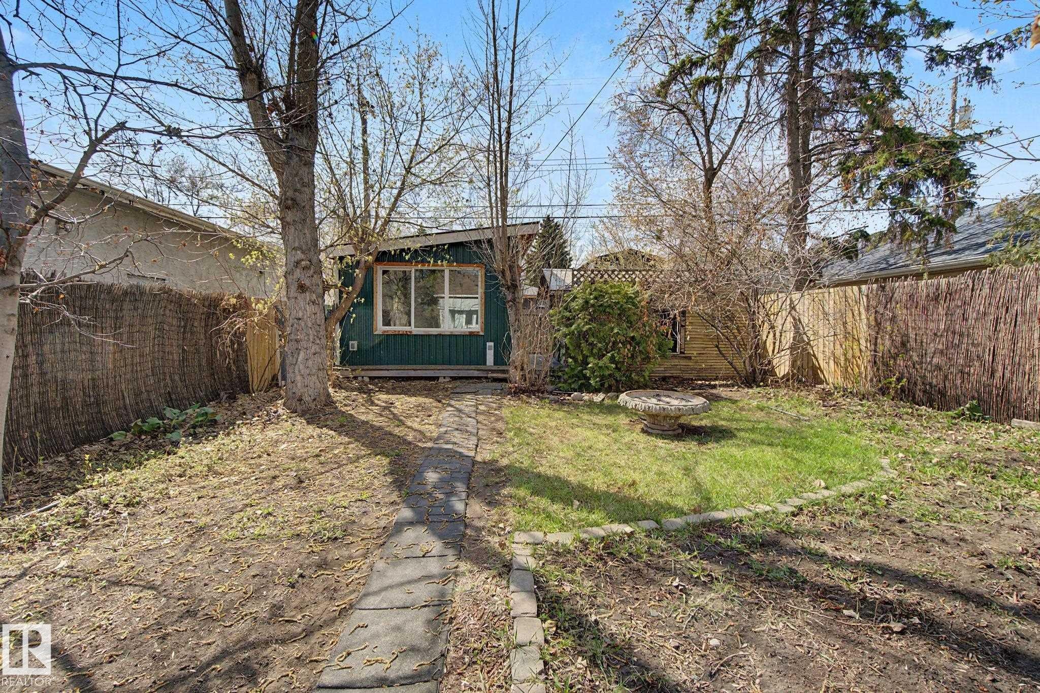 Rear property with a standalone structure featuring horizontal siding and multiple windows - 11512 122 St, Edmonton, AB - Outdoor