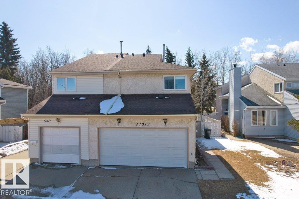 The property features a two-story exterior with a two-car garage, a paved driveway, and a shingled roof - 17313 60 Avenue, Edmonton, AB - Outdoor With Facade