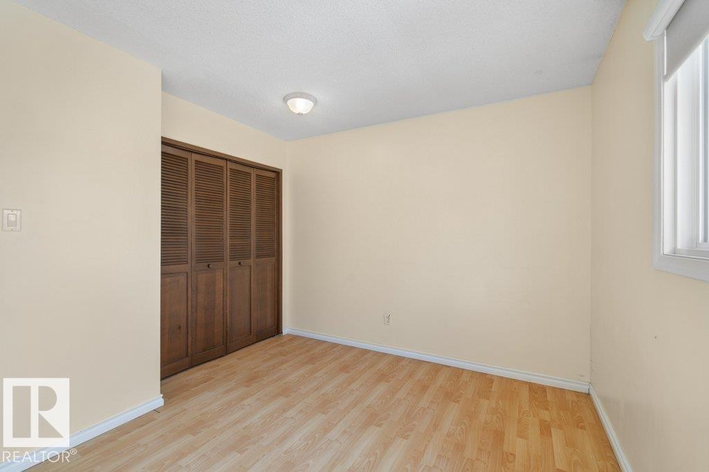 This room features light-colored walls, light wood-style flooring, and a window with vertical blinds - 17313 60 Avenue, Edmonton, AB - Indoor Photo Showing Other Room