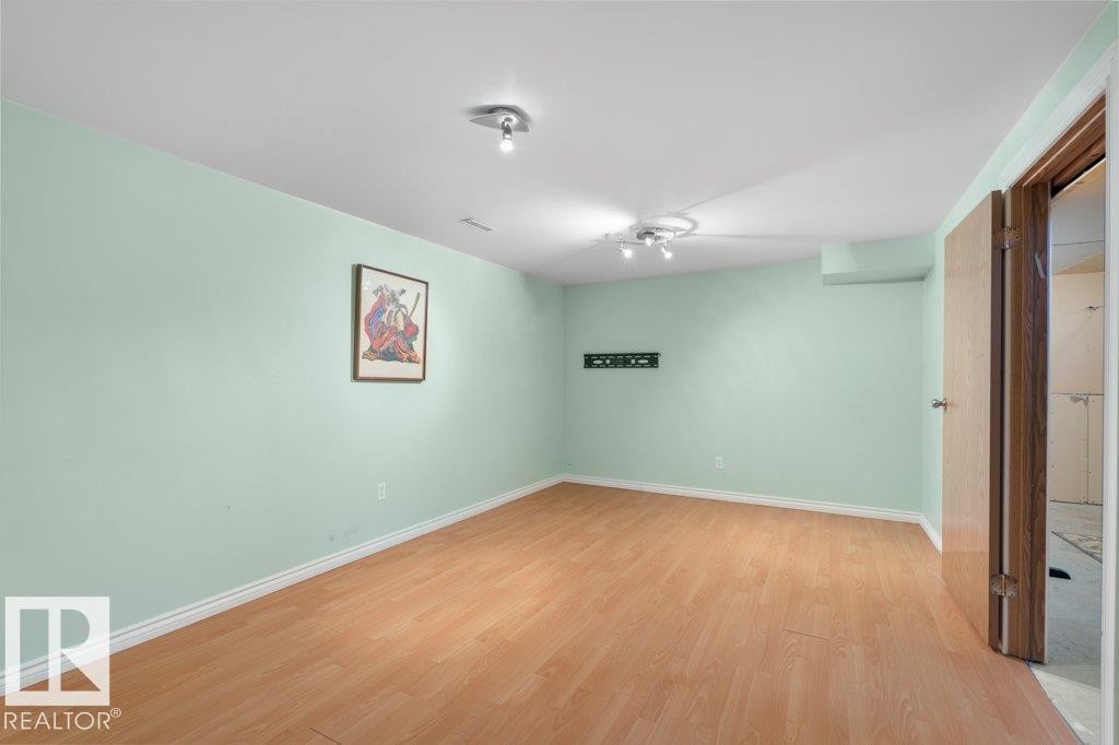 This room features light-colored walls and wood flooring, with a ceiling-mounted light fixture providing illumination - 17313 60 Avenue, Edmonton, AB - Indoor Photo Showing Other Room