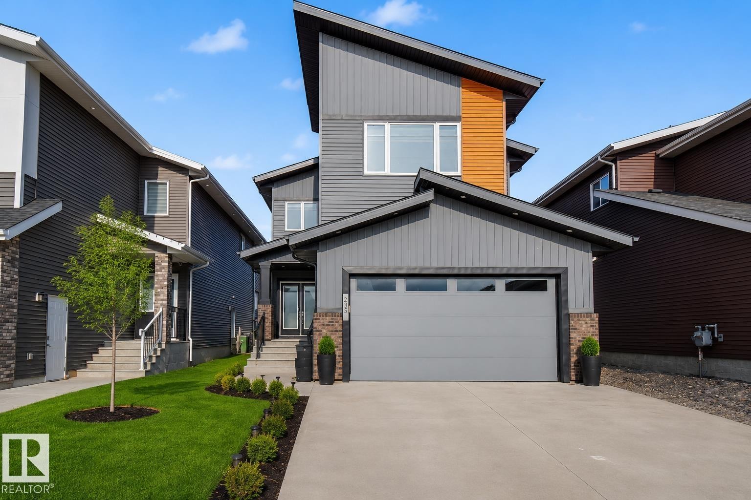 Contemporary exterior featuring a split-pitch roofline, a concrete driveway, and an integrated garage, Grass virtually enhanced to give a summer look. - 635 42 Street, Edmonton, AB - Outdoor