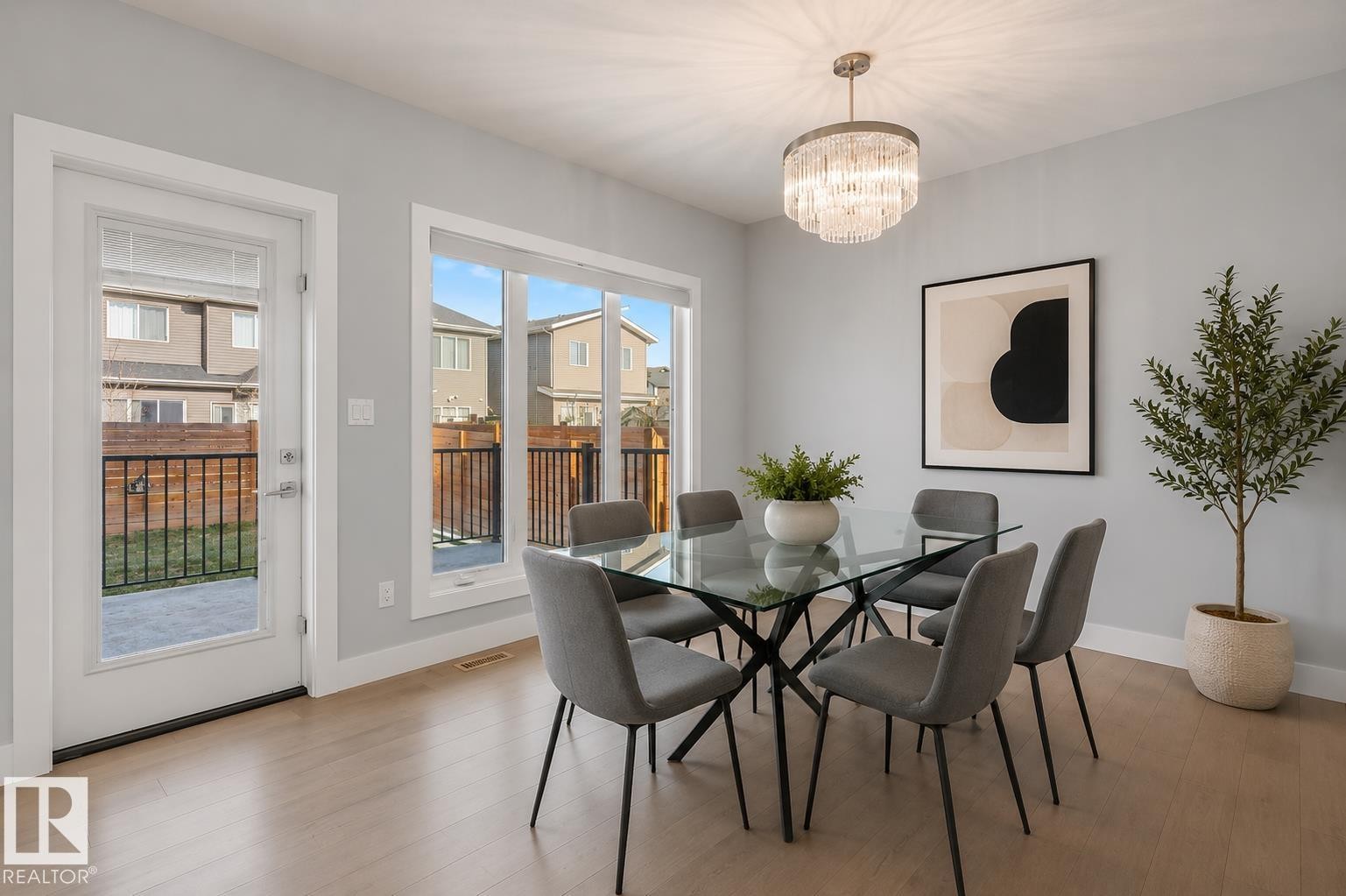 Bright dining area featuring light-toned wood-finish flooring and a contemporary chandelier. Virtually Staged. - 635 42 Street, Edmonton, AB - Indoor Photo Showing Dining Room