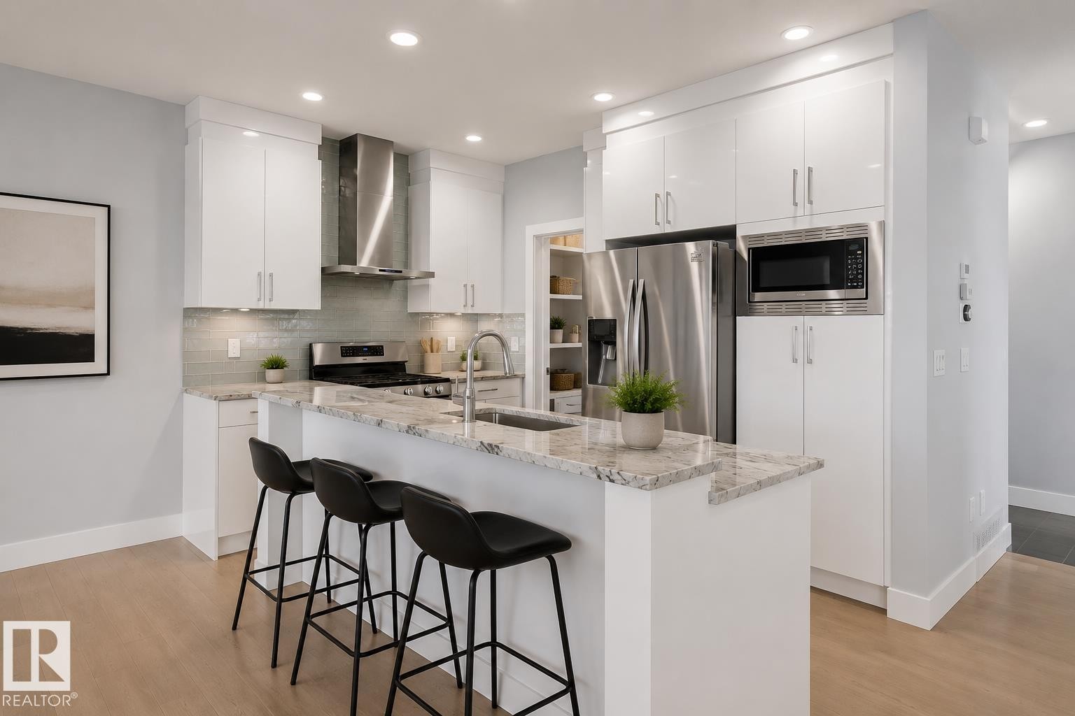 Modern kitchen featuring white cabinetry, stainless steel appliances, a tile backsplash, and a central island with a stone countertop. Virtually Staged. - 635 42 Street, Edmonton, AB - Indoor Photo Showing Kitchen With Upgraded Kitchen