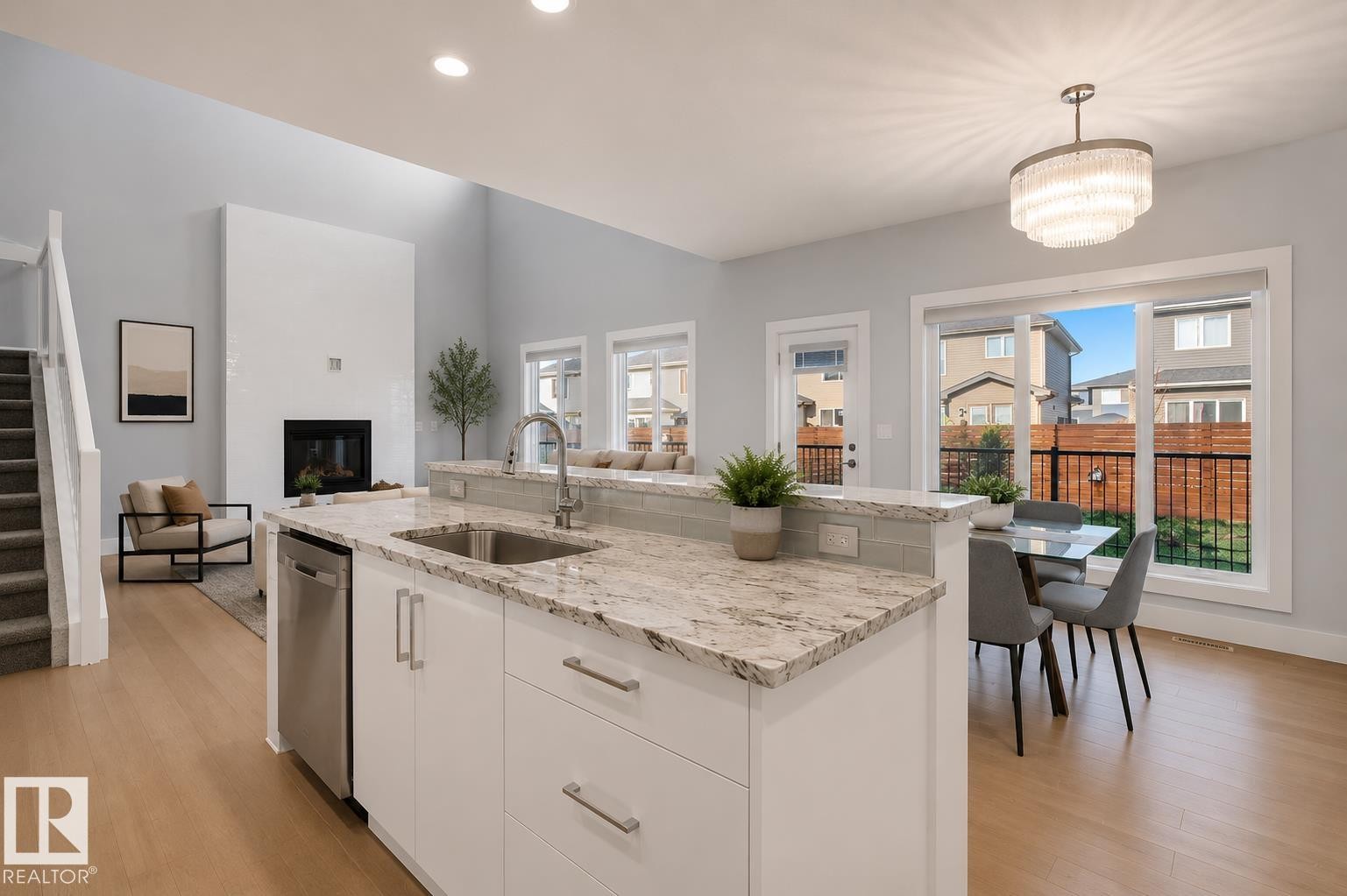 Kitchen island featuring a stainless steel sink and integrated dishwasher. Virtually Staged. - 635 42 Street, Edmonton, AB - Indoor