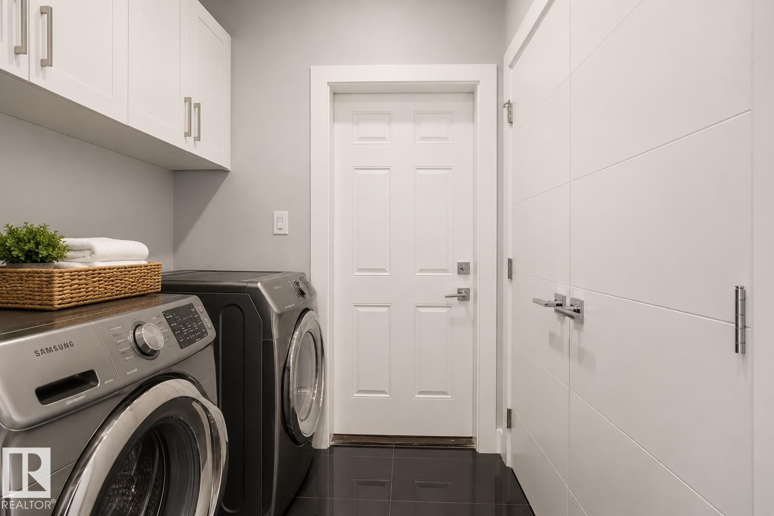 Laundry area featuring dark tile flooring and light gray wall paint. Virtually Staged.. Virtually Staged. - 635 42 Street, Edmonton, AB - Indoor Photo Showing Laundry Room