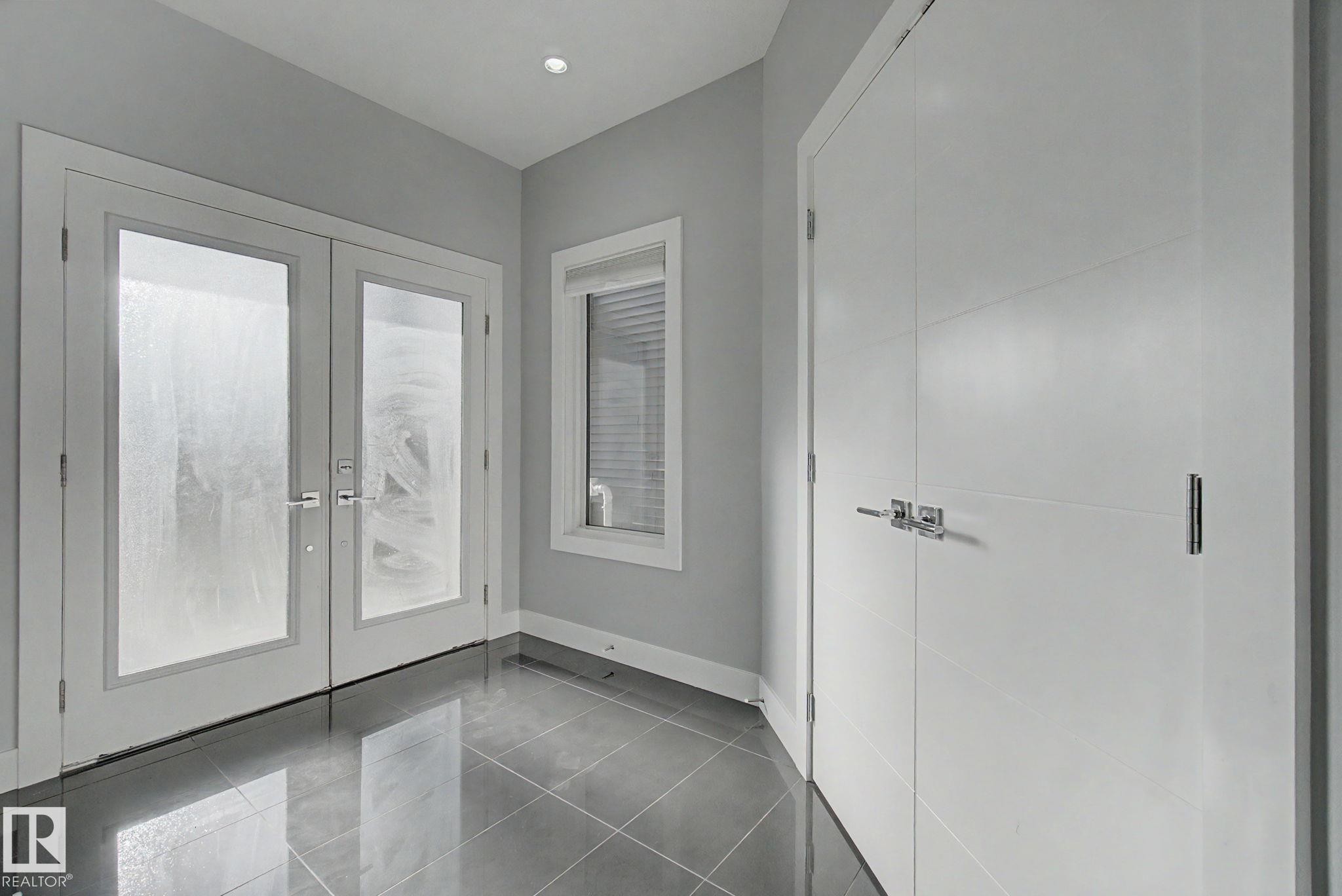 Entryway featuring reflective tile flooring, recessed lighting, and a window with blinds - 635 42 Street, Edmonton, AB - Indoor Photo Showing Other Room
