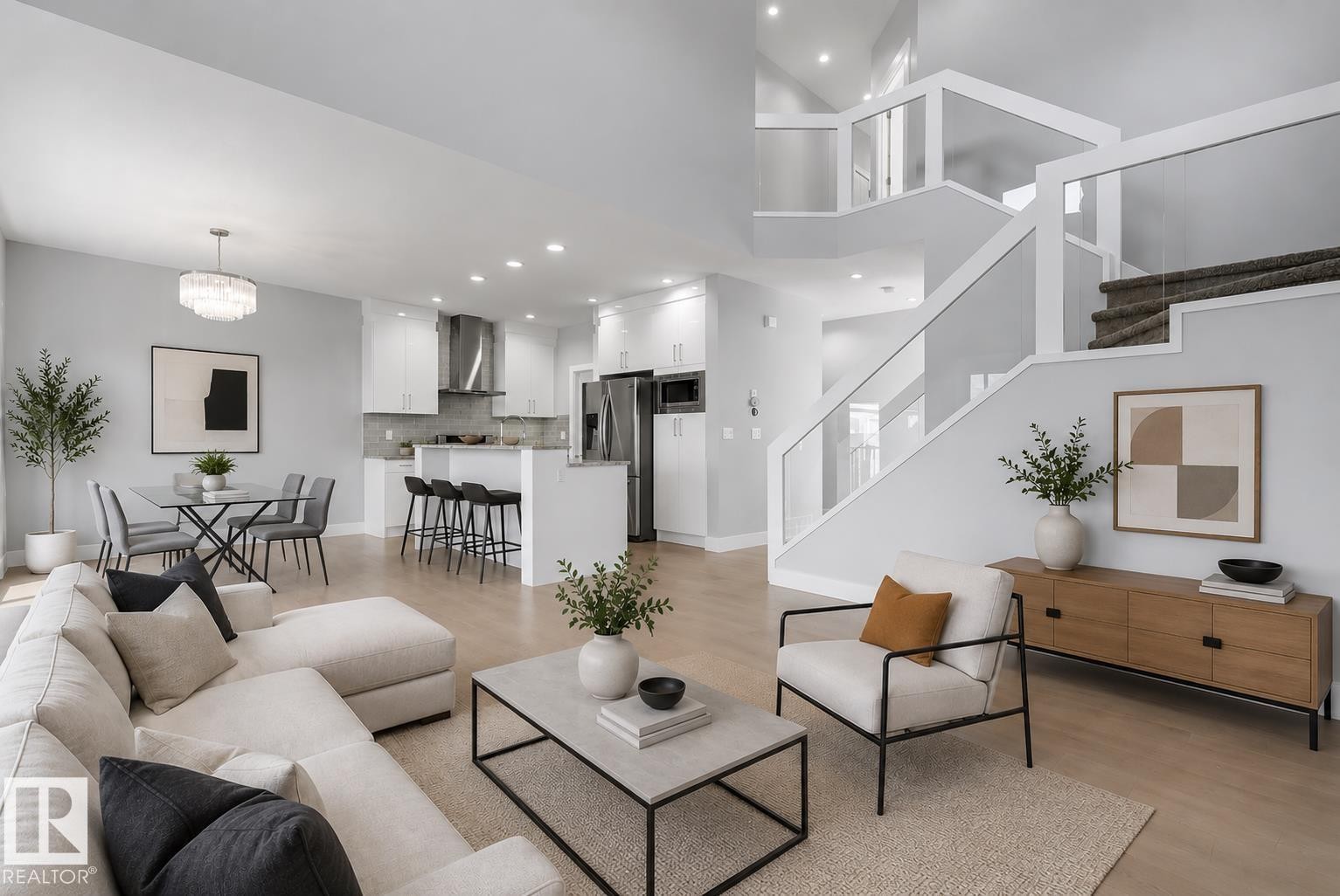 Open concept living space featuring wood-finish flooring throughout, a modern kitchen with stainless steel appliances, a dining area with contemporary lighting, and a multi-level staircase with glass railings. Virtually Staged. - 635 42 Street, Edmonton, AB - Indoor Photo Showing Living Room