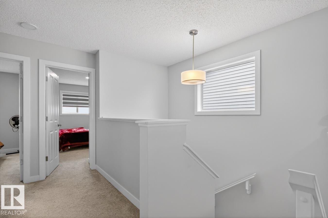 Stairwell featuring a contemporary drum pendant light, white window trim, and a textured ceiling - 3214 9 Street, Edmonton, AB - Indoor Photo Showing Other Room