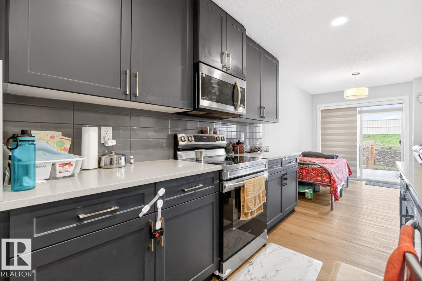 Modern kitchen featuring dark grey cabinetry, light-toned countertops, and a subway tile backsplash - 3214 9 Street, Edmonton, AB - Indoor Photo Showing Kitchen With Upgraded Kitchen