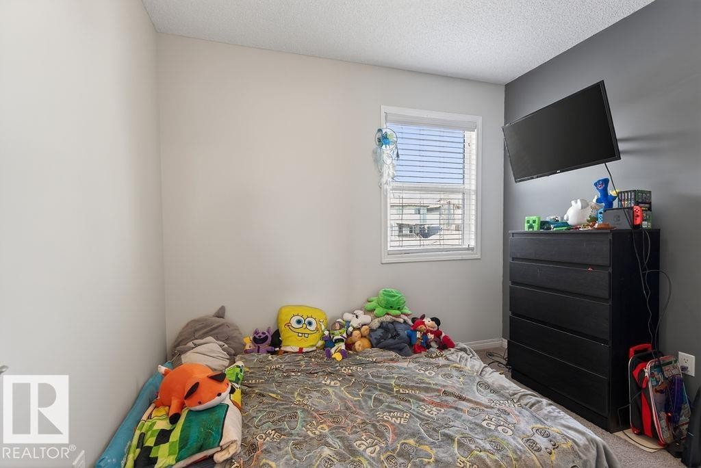 Interior room featuring a window with blinds, light-colored walls, and a gray accent wall - 17540 58 Street Nw, Edmonton, AB