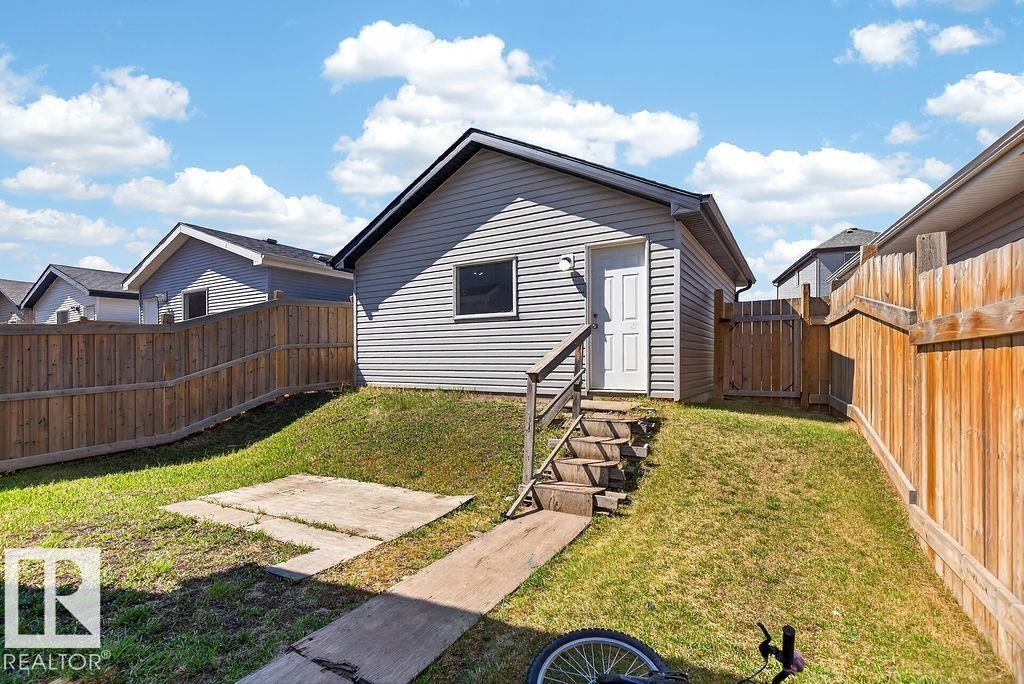 Detached garage with horizontal siding, a single window, and exterior lighting - 17540 58 Street Nw, Edmonton, AB