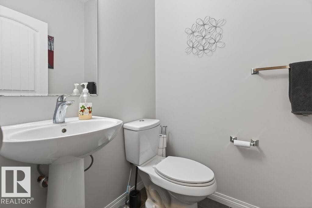 Pedestal sink with chrome faucet and framed mirror - 17540 58 Street Nw, Edmonton, AB
