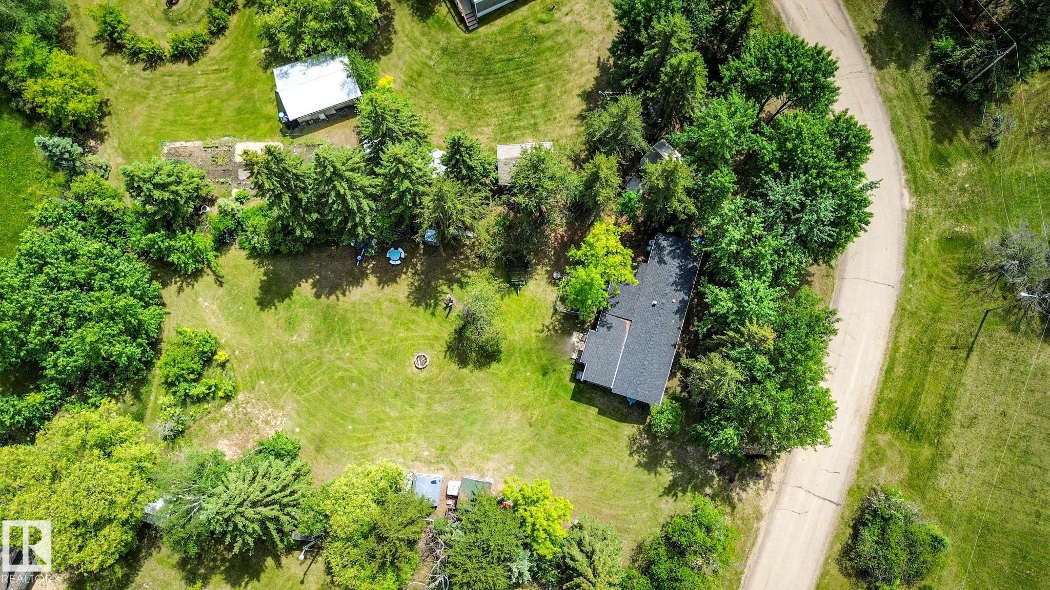 Expansive property featuring a curved access road, established trees, and a detached structure - 331 60417 Range Road 124, Rural St. Paul County, AB