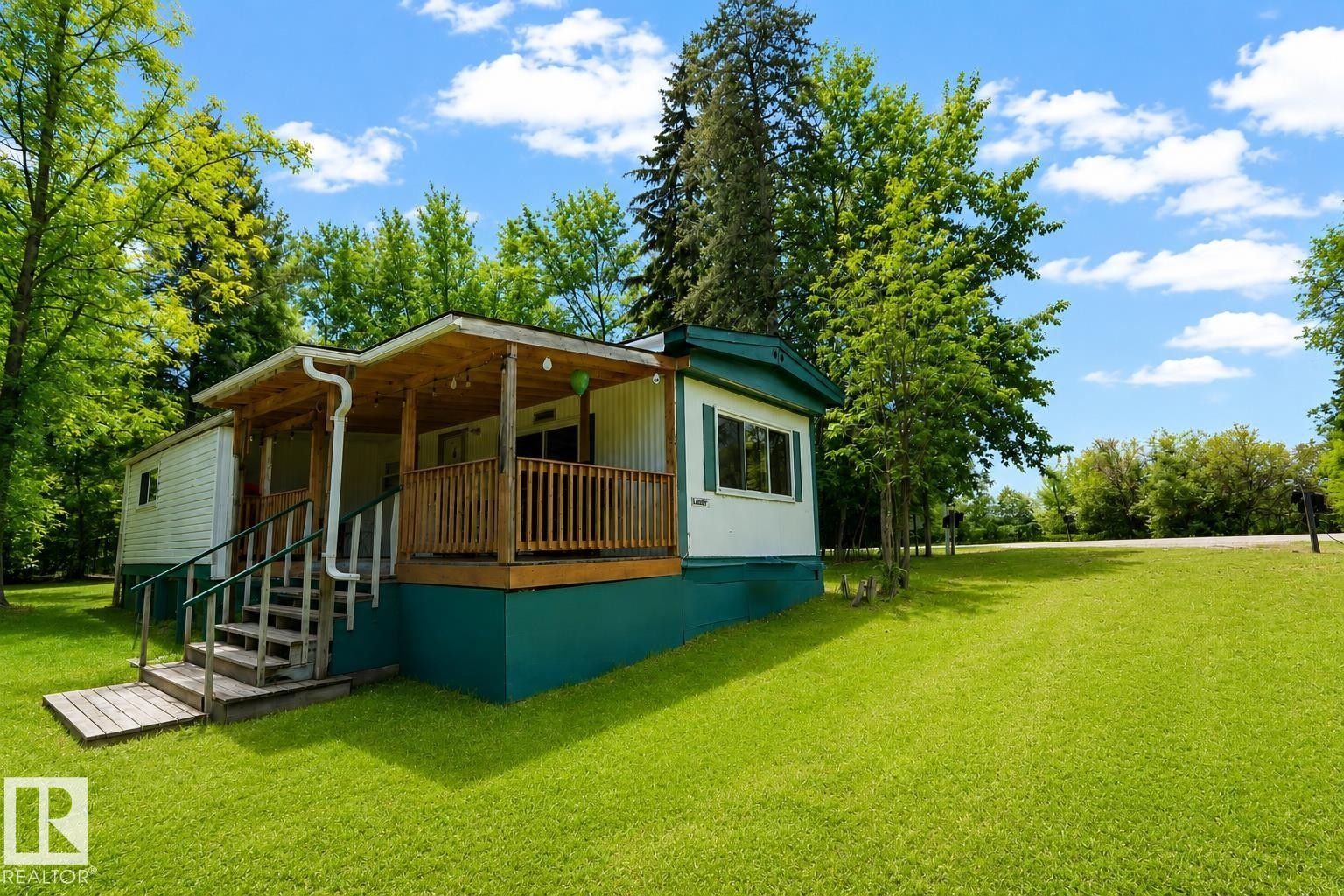 White siding exterior with a teal foundation and trim - 331 60417 Range Road 124, Rural St. Paul County, AB