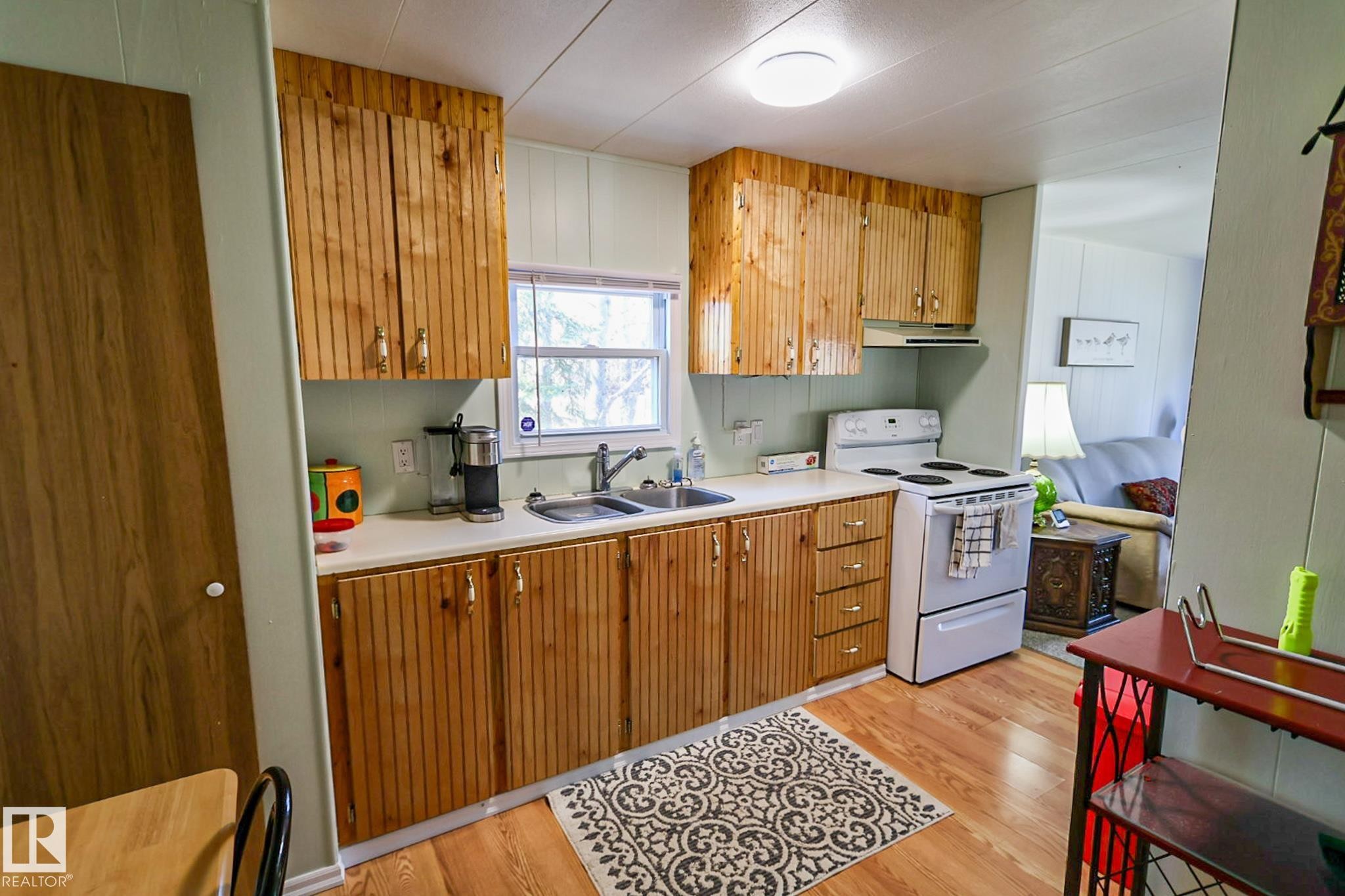 Kitchen featuring wood-finish cabinetry and matching wood-finish flooring - 331 60417 Range Road 124, Rural St. Paul County, AB