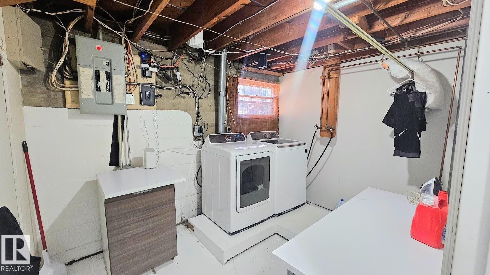 Laundry area featuring an exposed beam ceiling, concrete foundation, and a small casement window - 12339 89 Street, Edmonton, AB - Indoor Photo Showing Laundry Room