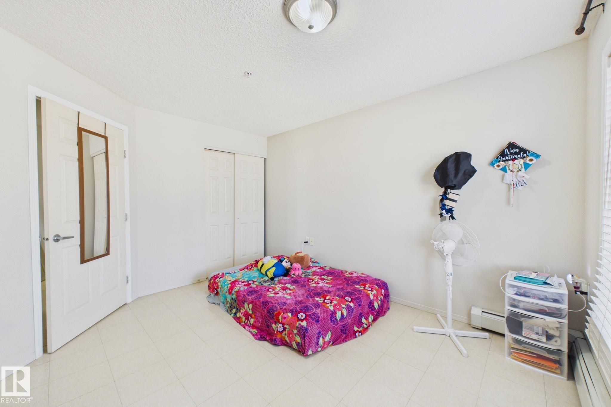 Interior room featuring light-toned flooring, white walls, and a textured ceiling - 220 80A Kelloway Crescent, Red Deer, AB - Indoor Photo Showing Bedroom